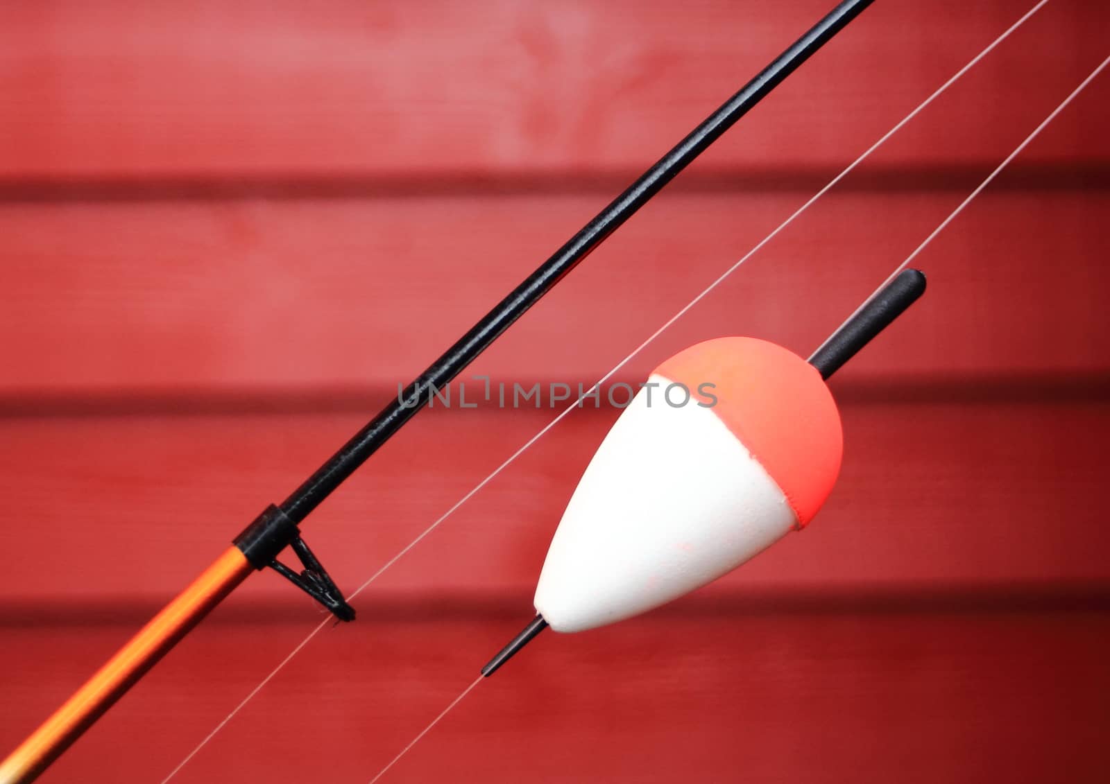 Red and white bobber on a fishing rod