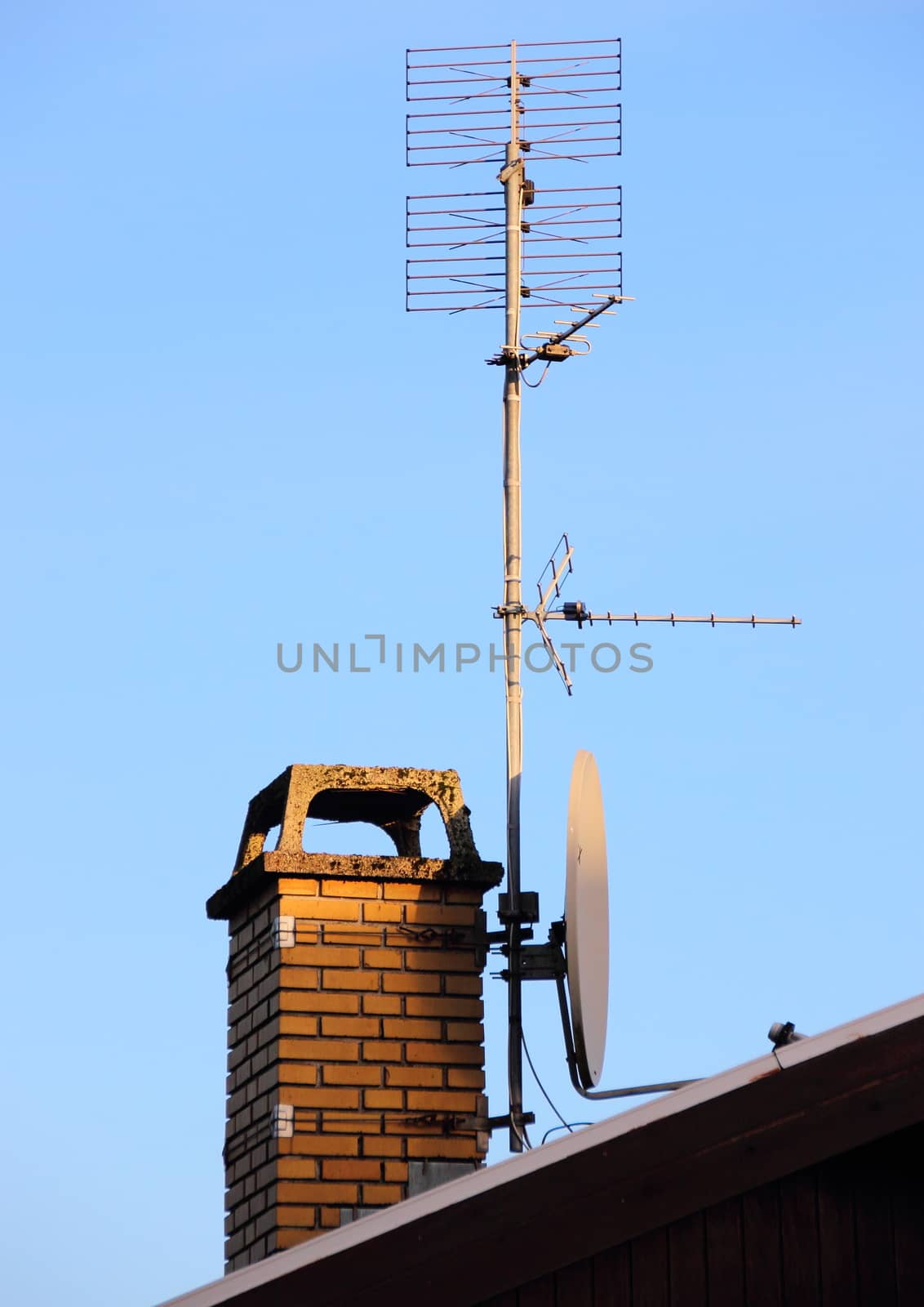Antenna and satellite dish on a chimney