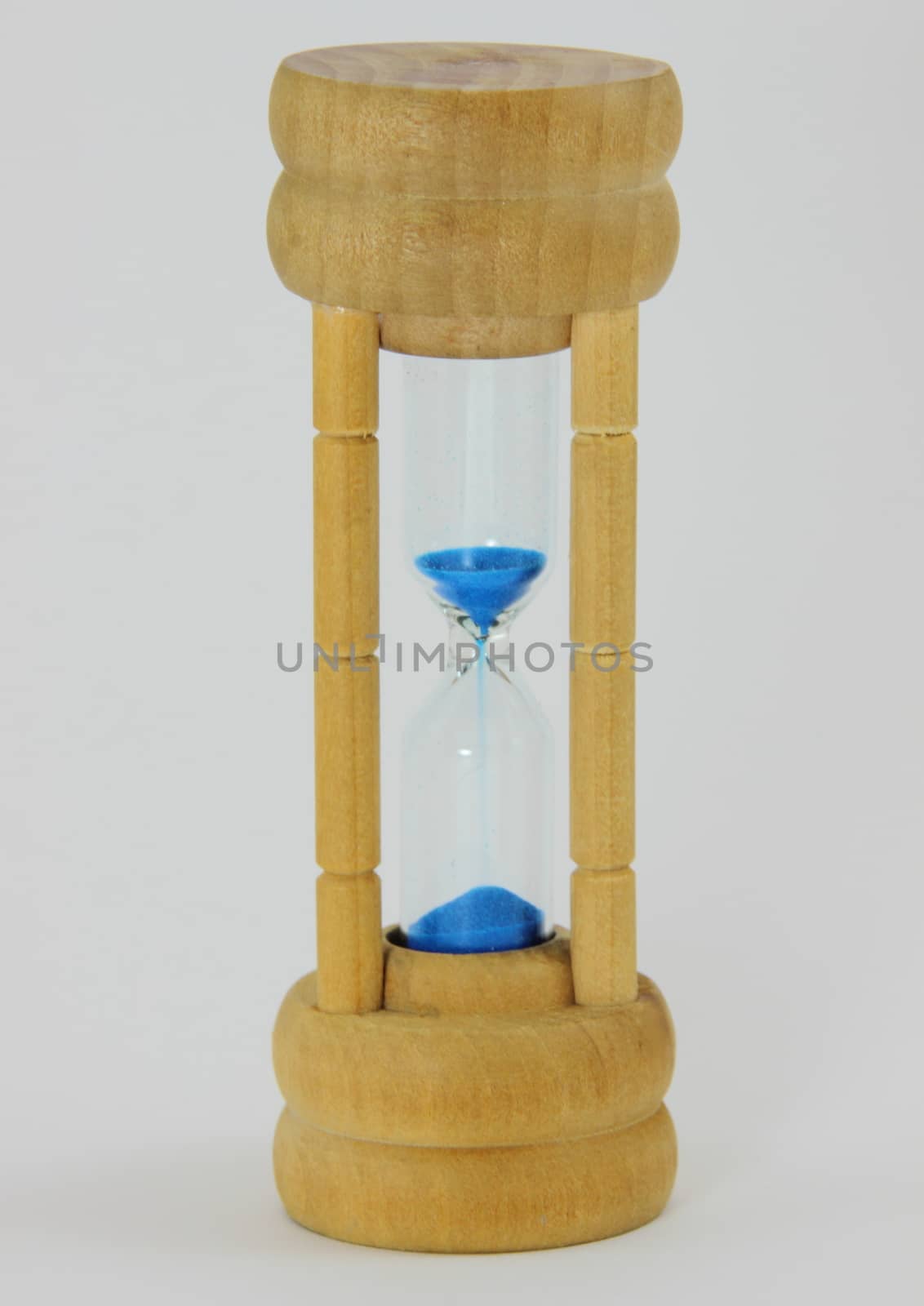 Isolated light pine hourglass with blue sand