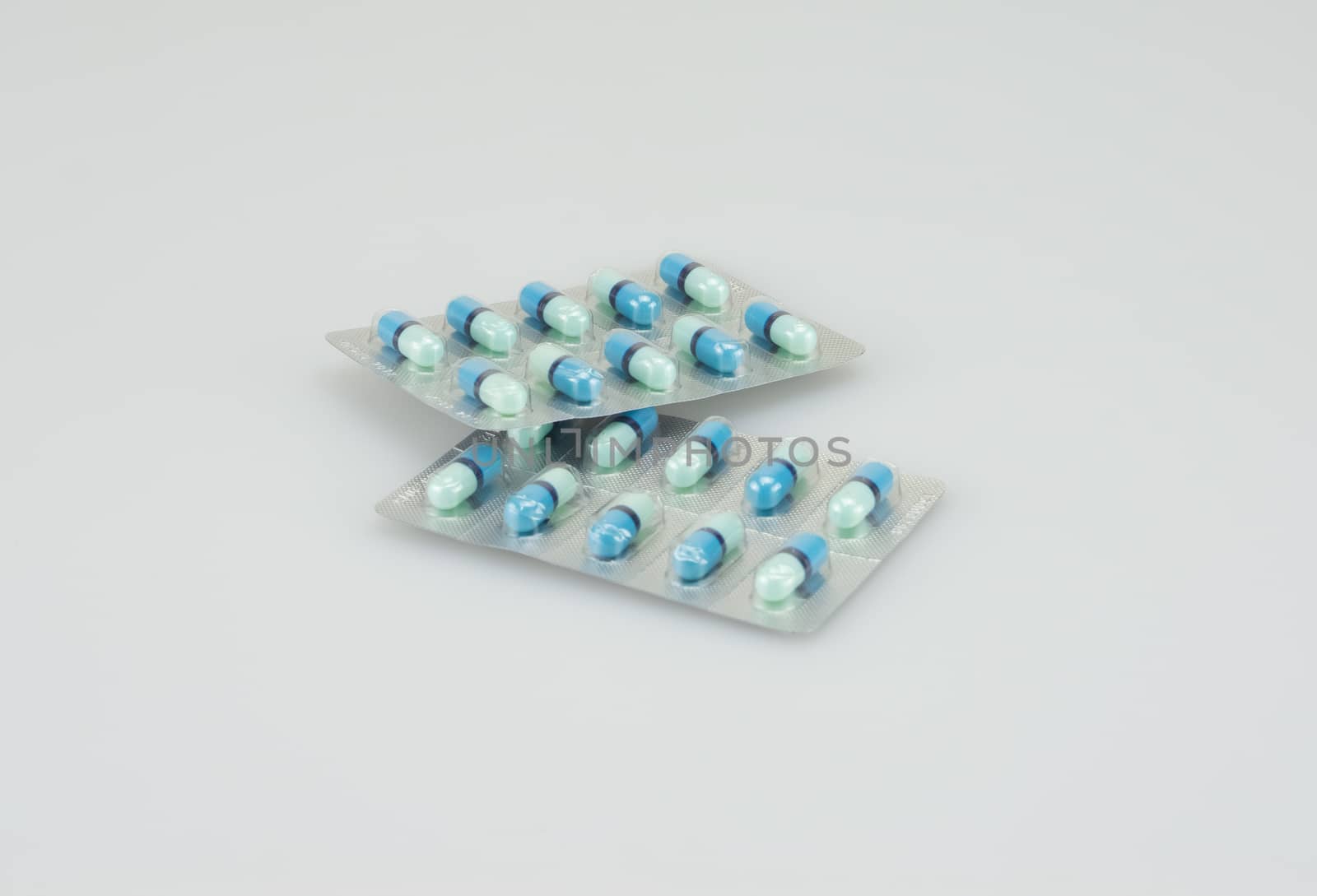 Two packing of blue medical capsules was placed on white background.