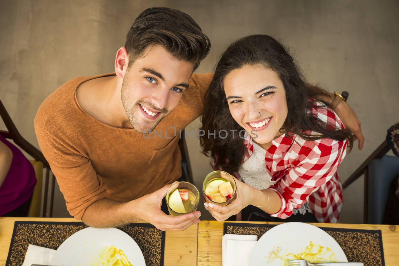 Young couple toasting and looking happy at a restaurant