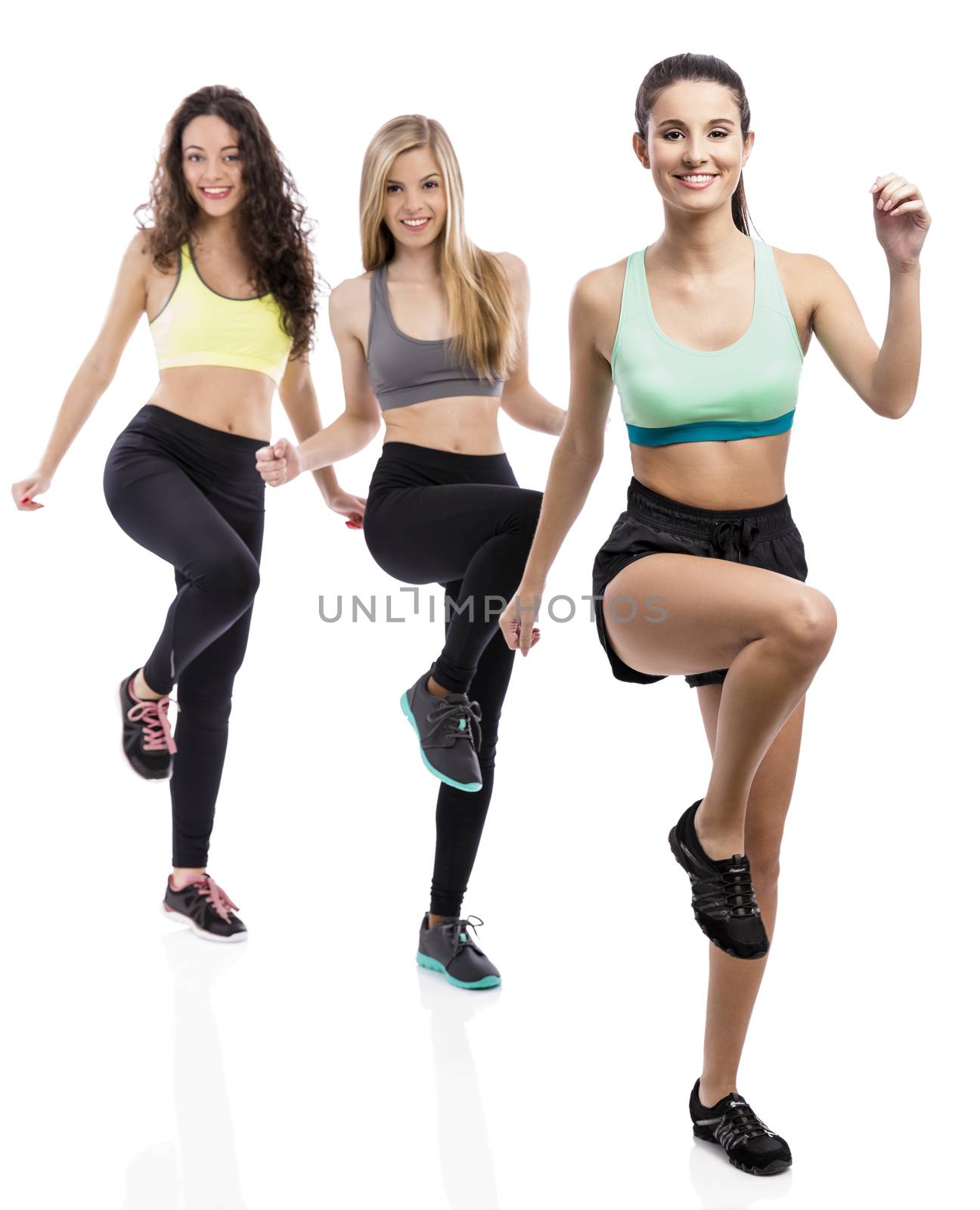 Portrait of three beautiful athletic girls making group exercises