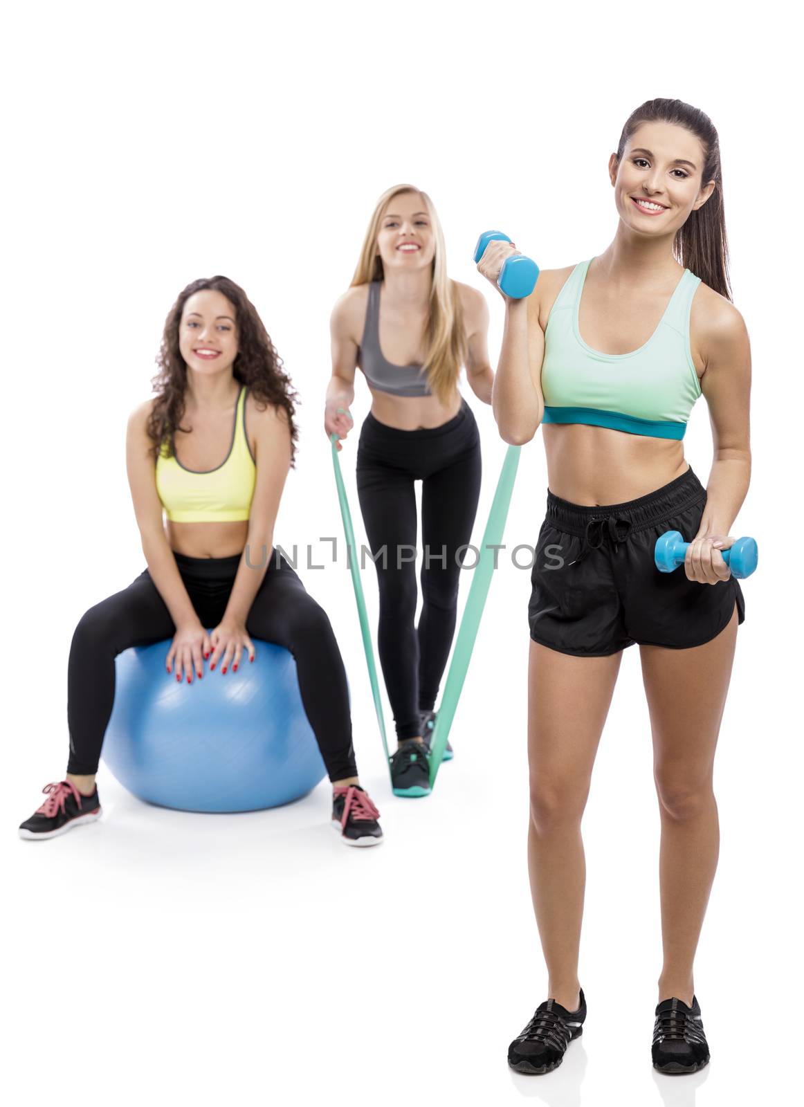 Portrait of three beautiful athletic girls in the gym