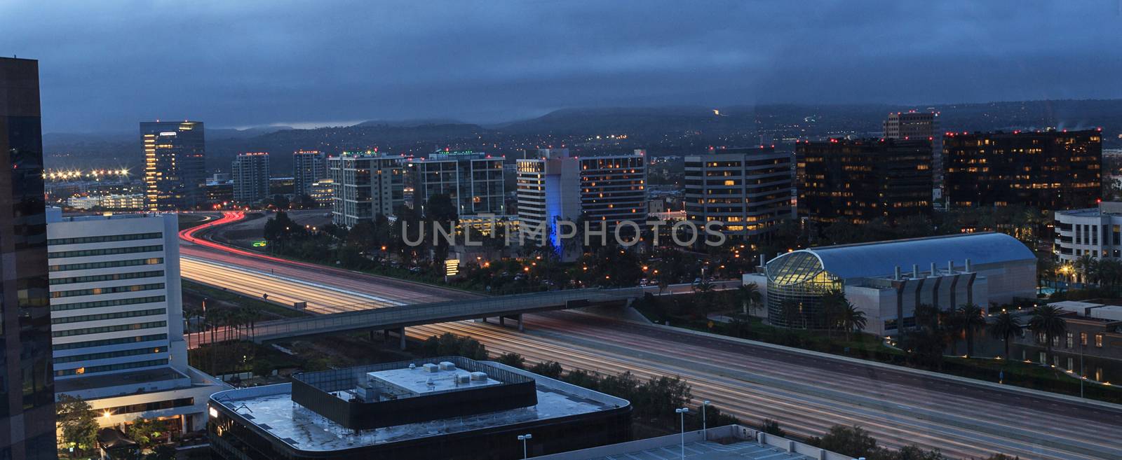 Car Headlights lights on a highway in Southern California, Orange County at dusk.