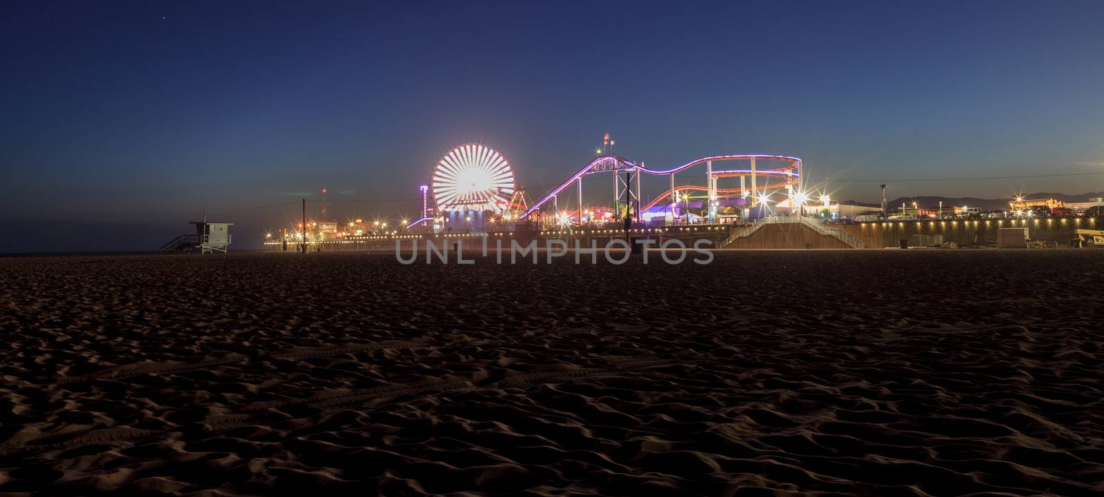 Santa Monica Pier boardwalk lit up at night by steffstarr