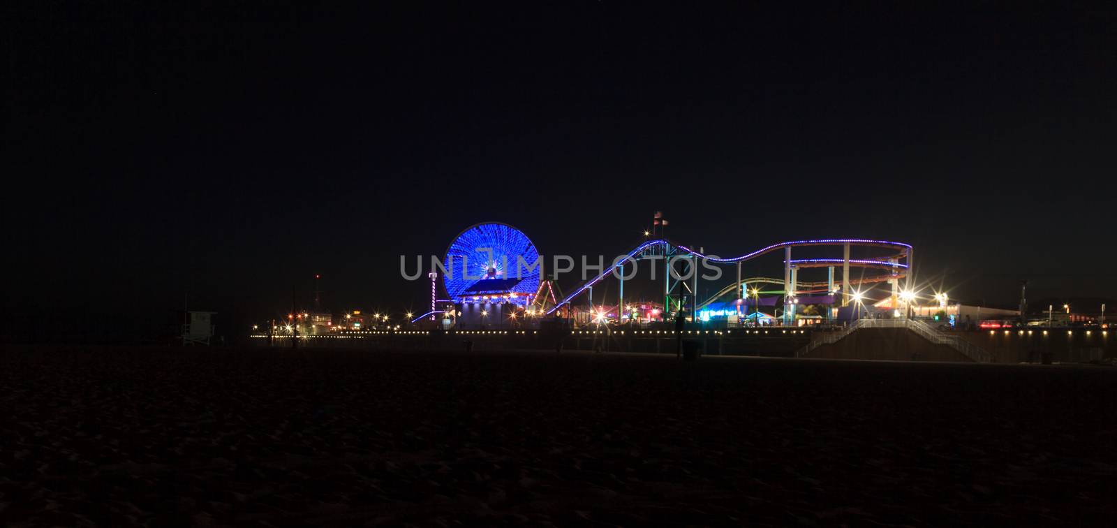 Santa Monica Pier boardwalk lit up at night by steffstarr