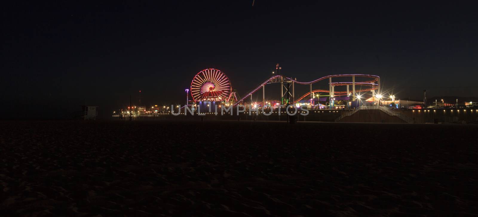 Santa Monica Pier boardwalk lit up at night by steffstarr