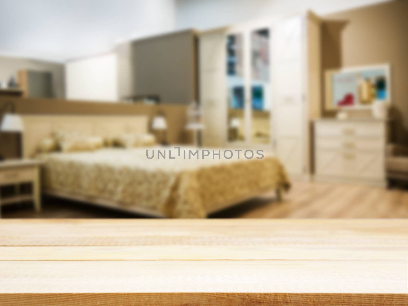 Wooden board empty table in front of blurred background. Perspective light wood over blur in modern comfortable bedroom with beige bed. Mock up for display or montage your products