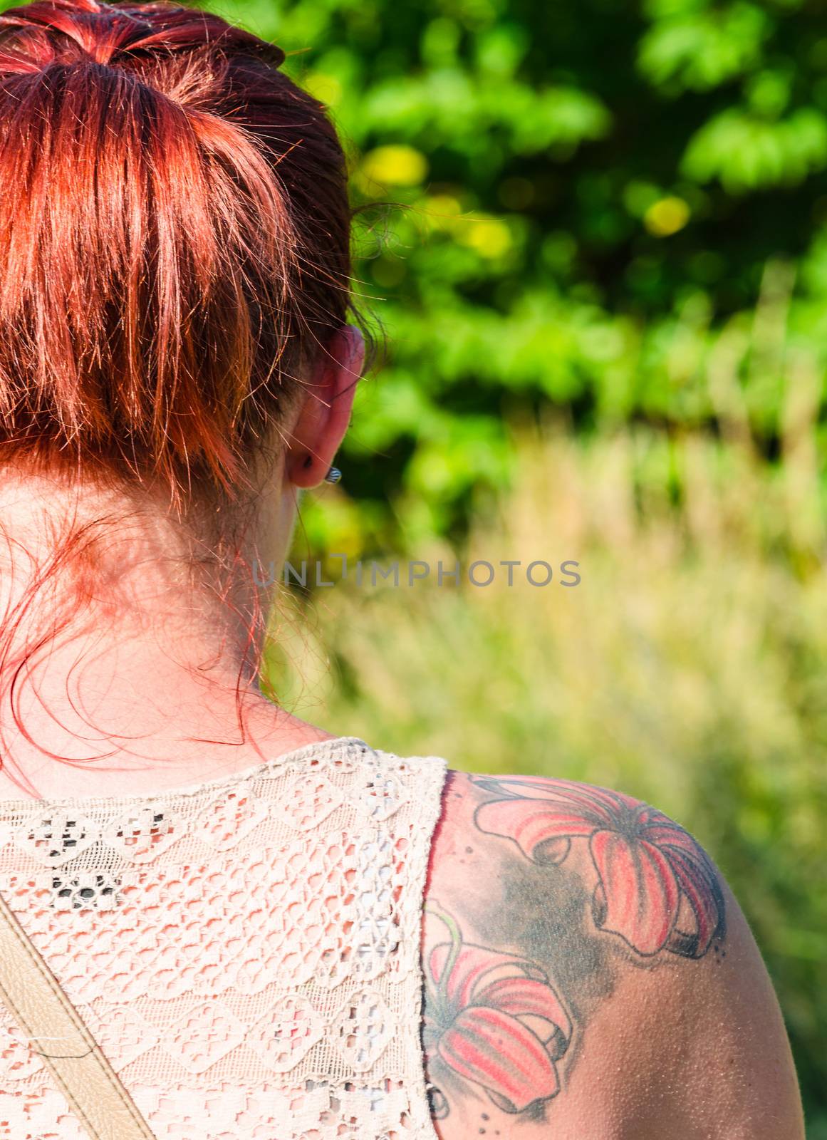 Young woman with flowers tattoo on her right shoulder blade. Image isolated.