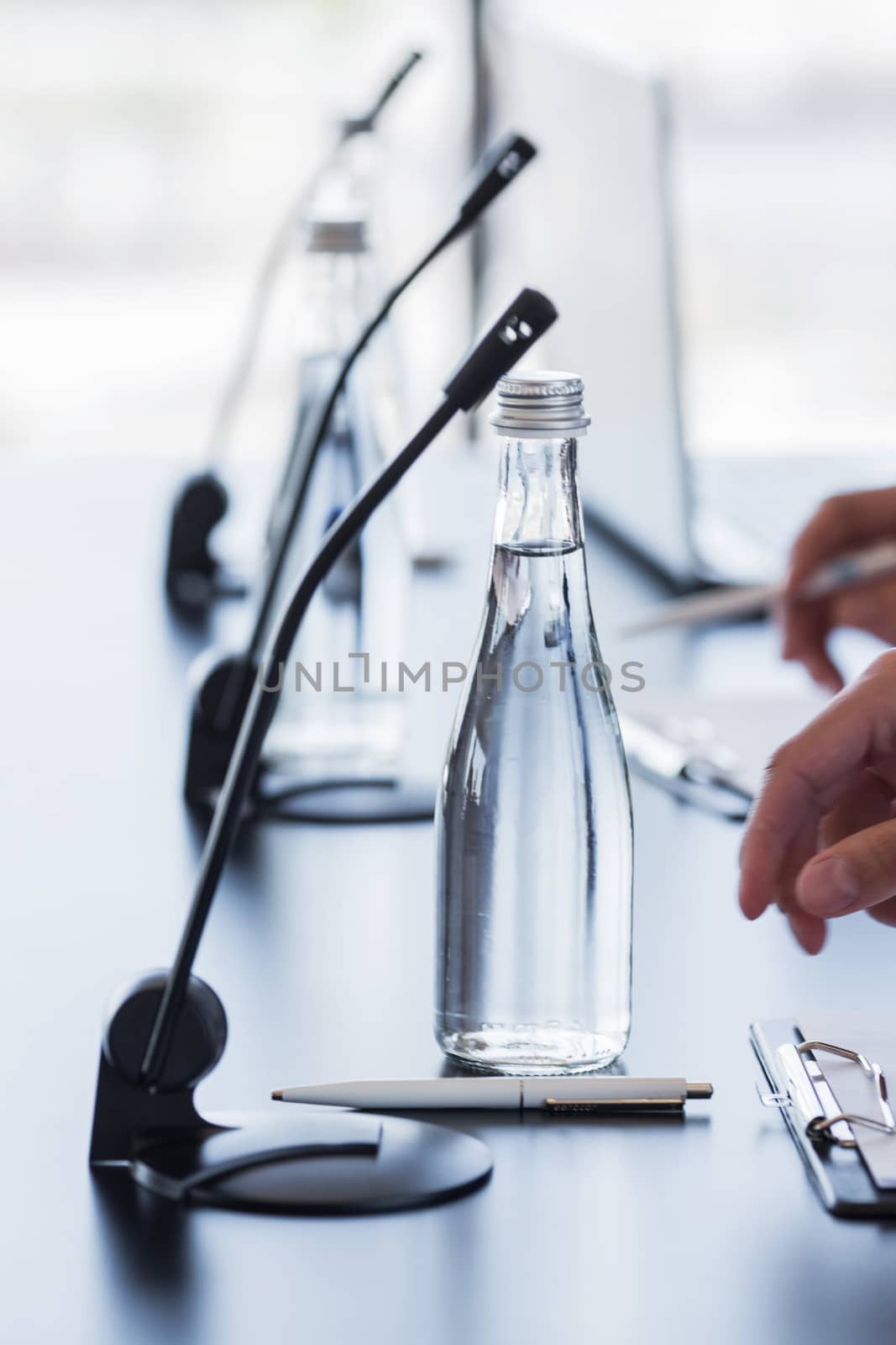 Microphones on table in conference room and business man hands 