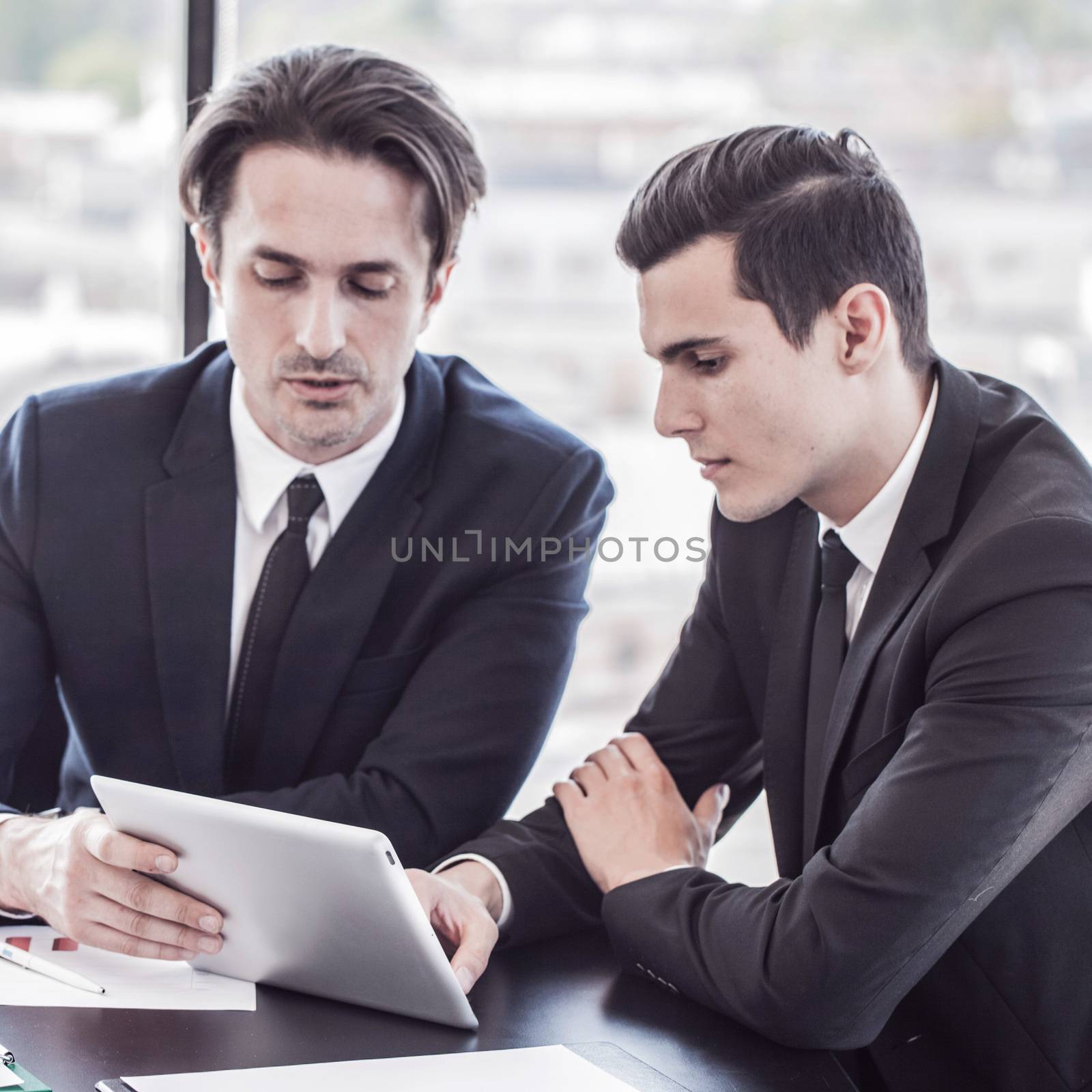 Business people discussing the charts and graphs showing the results of their successful teamwork