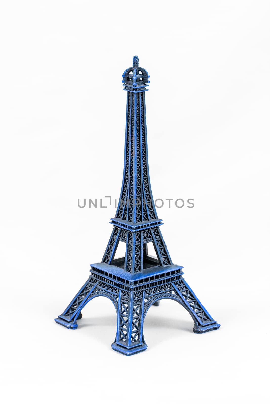 Close up shot of a blue miniature model of the Eiffel Tower isolated on a white background