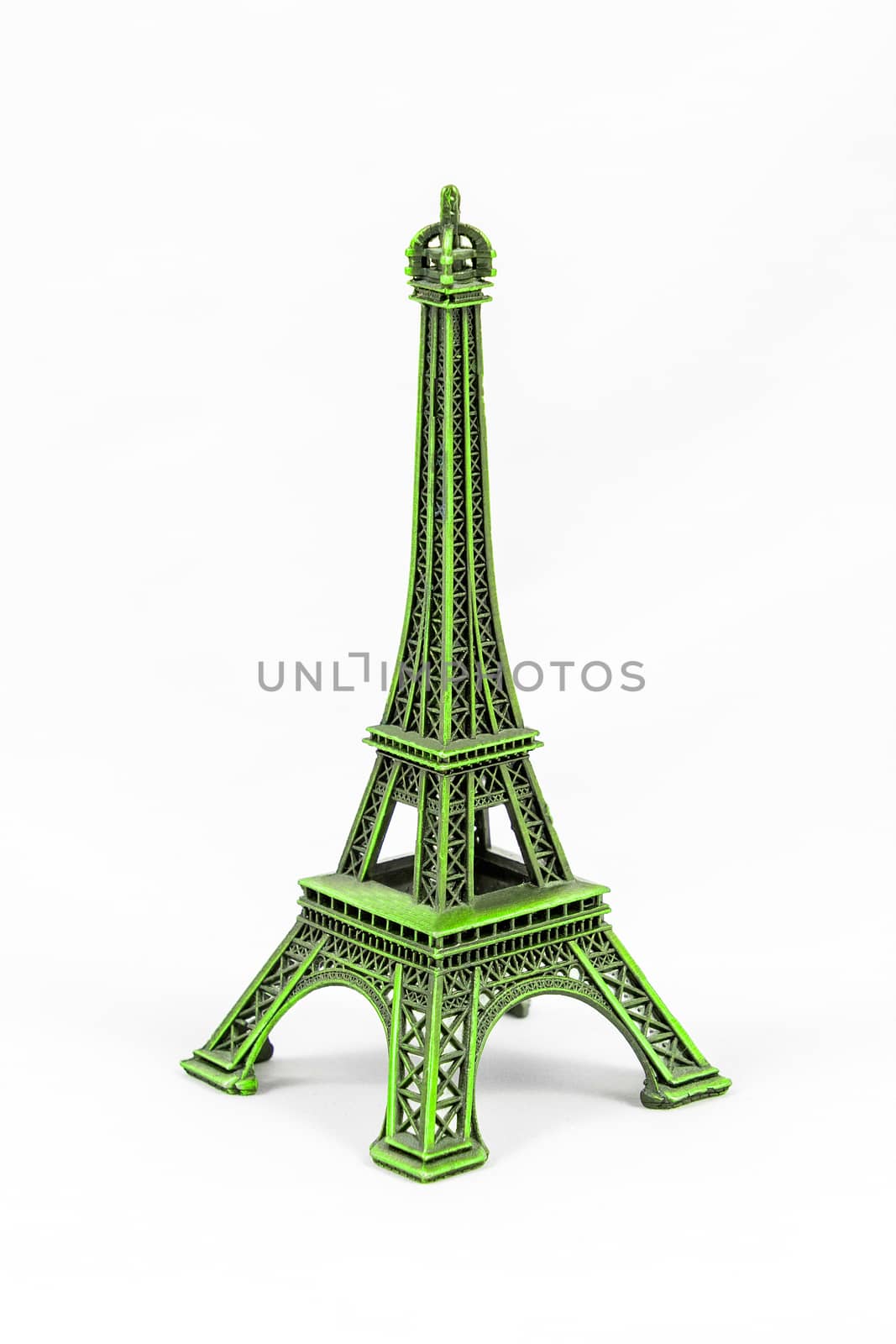 Close up shot of a green miniature model of the Eiffel Tower isolated on a white background