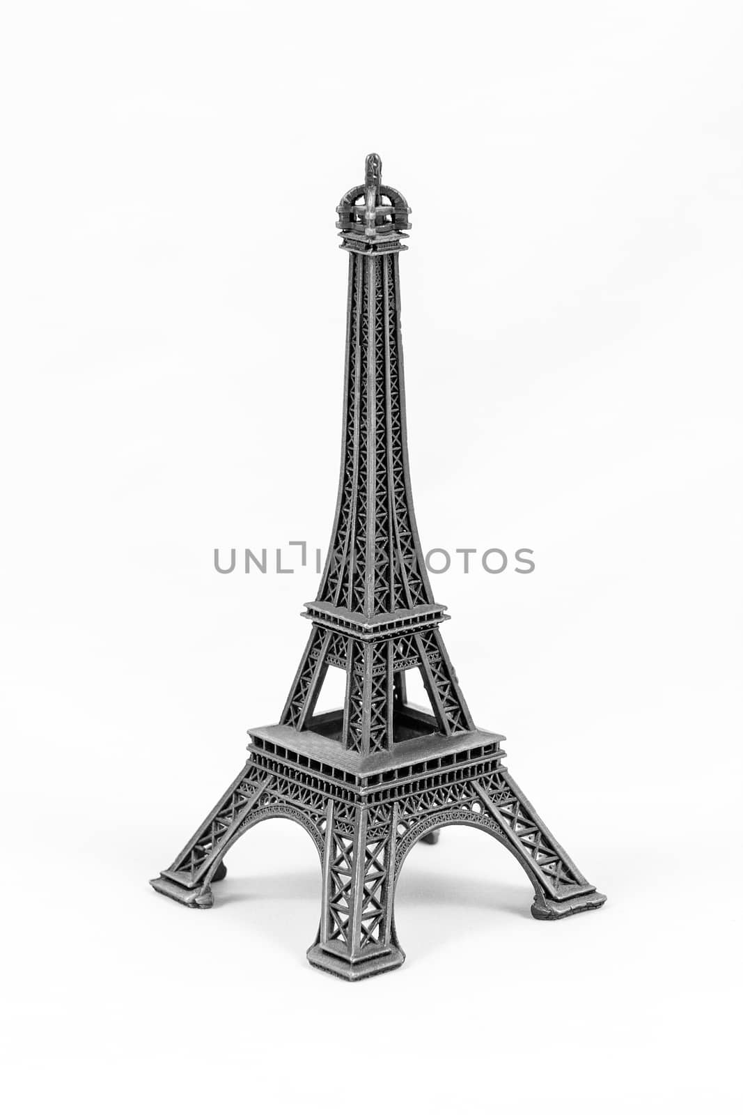 Close up shot of a gray miniature model of the Eiffel Tower isolated on a white background