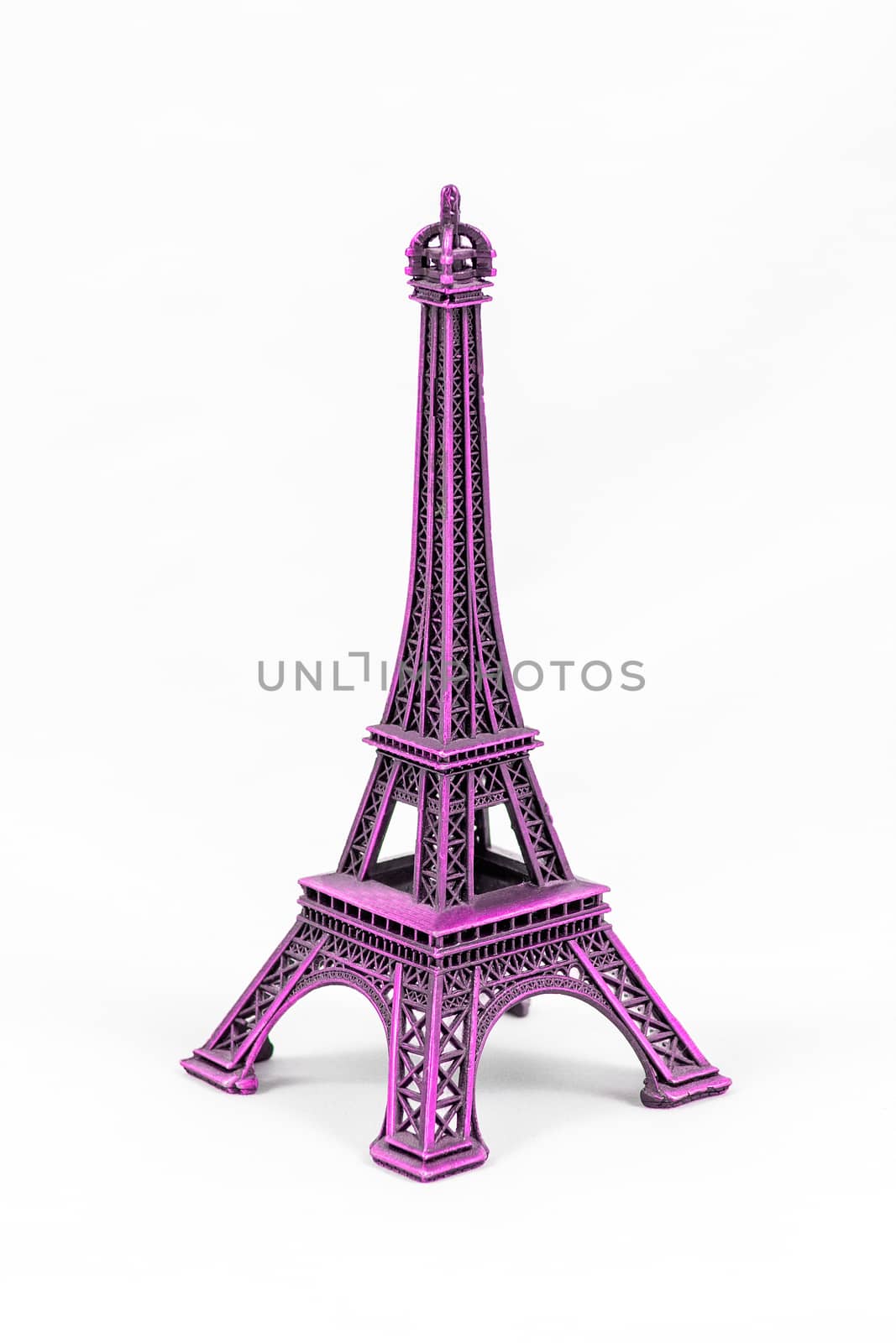 Close up shot of a purple miniature model of the Eiffel Tower isolated on a white background