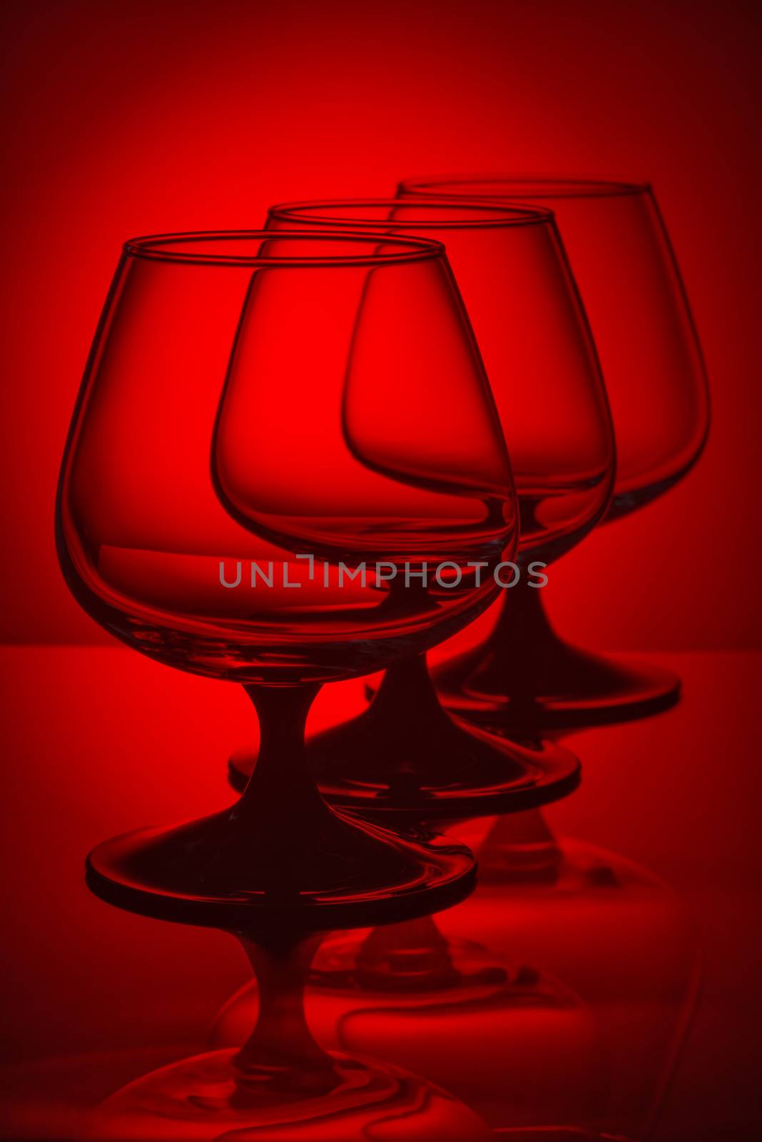 Three empty glasses in red light