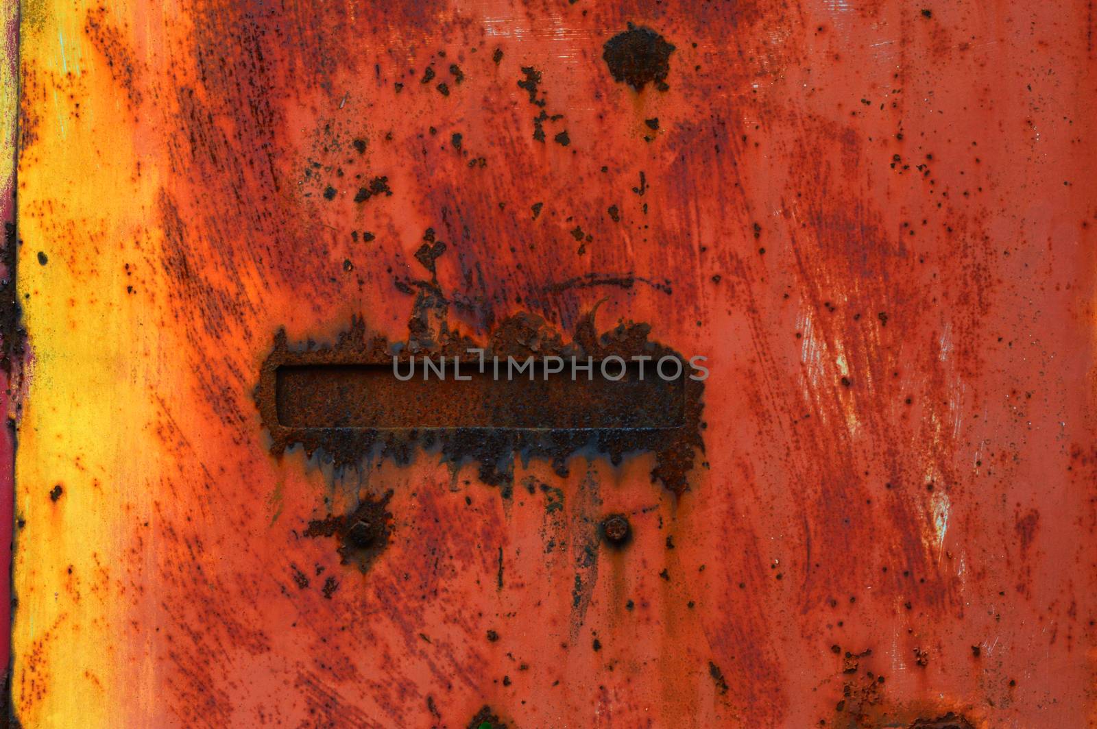 A closeup of a painted rusty metal background with red and yellow