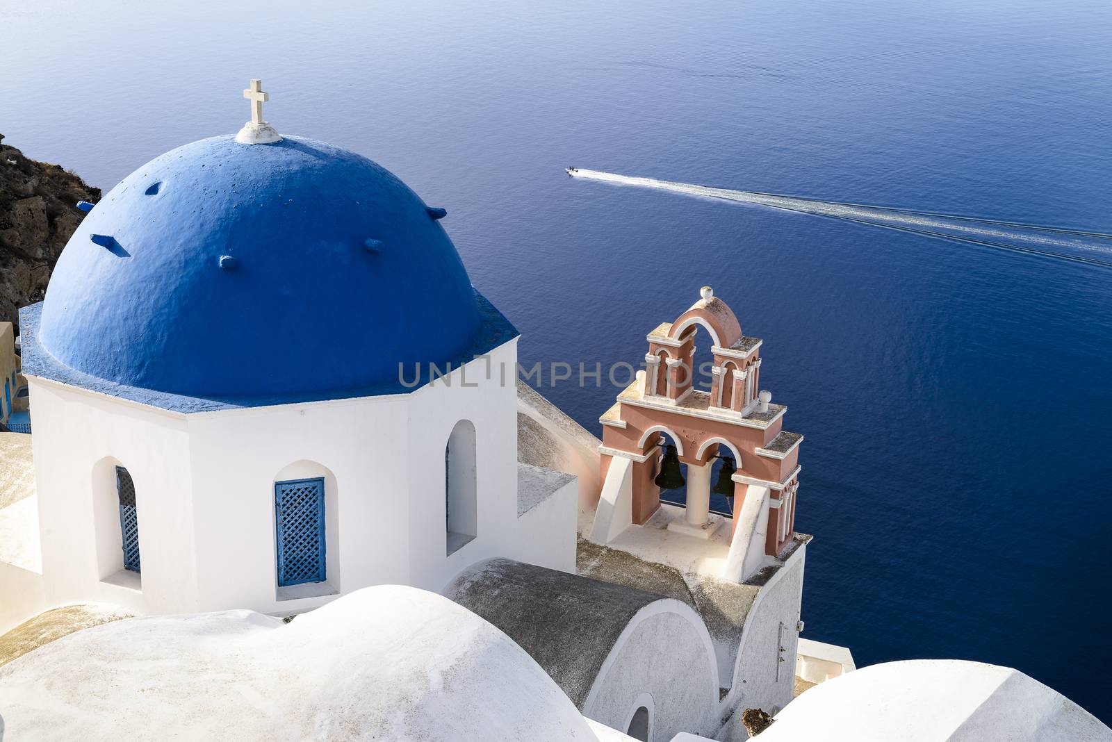 Oia town on Santorini island, Greece. Traditional and famous houses and churches with blue domes over the Caldera, Aegean sea