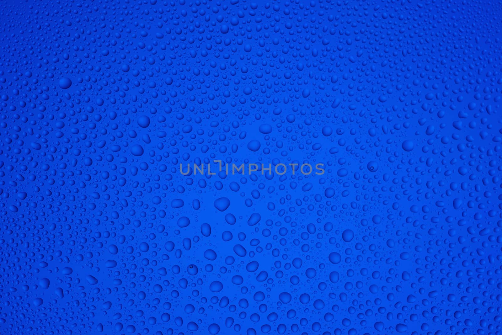 Background from drops of the different size on blue glass by fotooxotnik