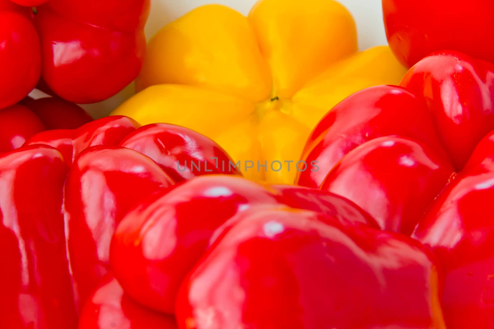 Photo of red and yellow raw pepper on white background