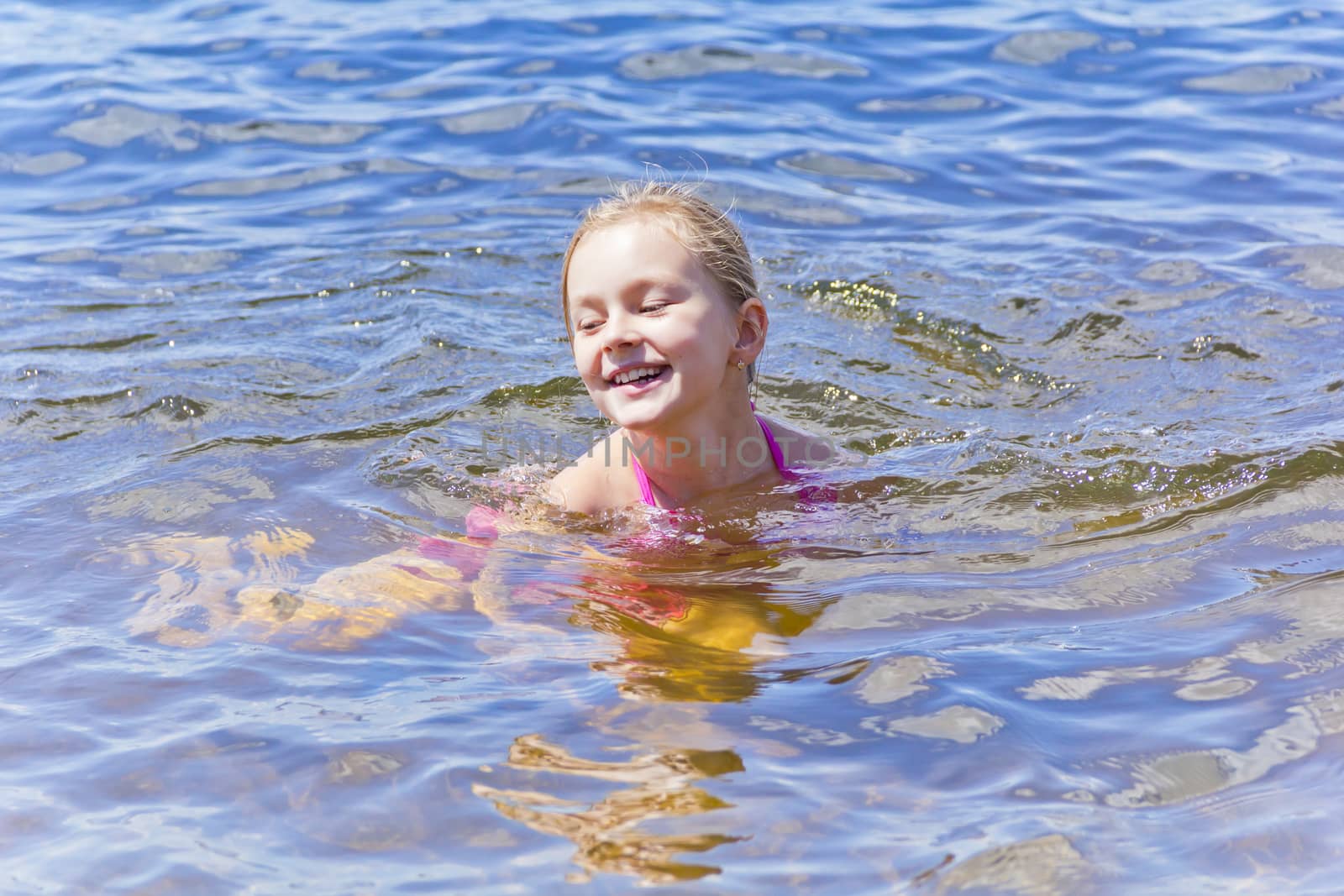 Swimming smiling cute girl seven years old