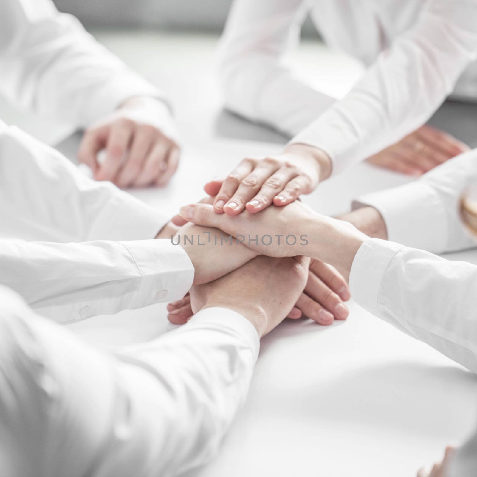 Business people joining hands by ALotOfPeople