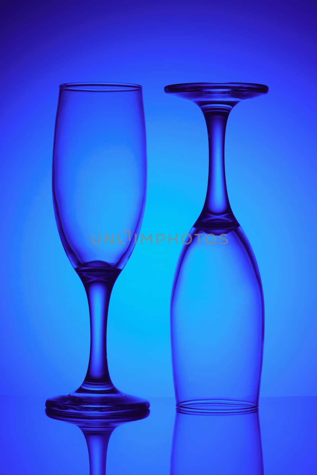 Two empty glasses in blue light