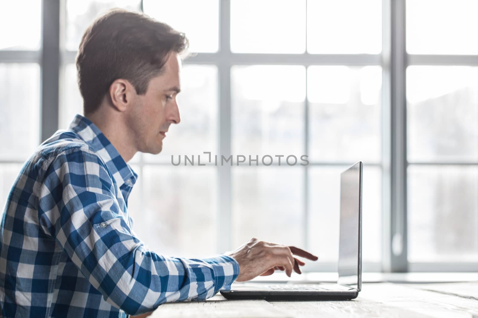 Man in casual clothes using a laptop computer in office