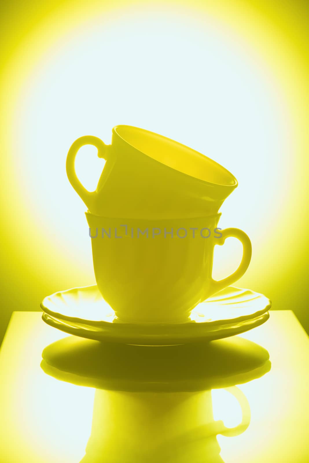 Cups for tea with saucers on a yellow background