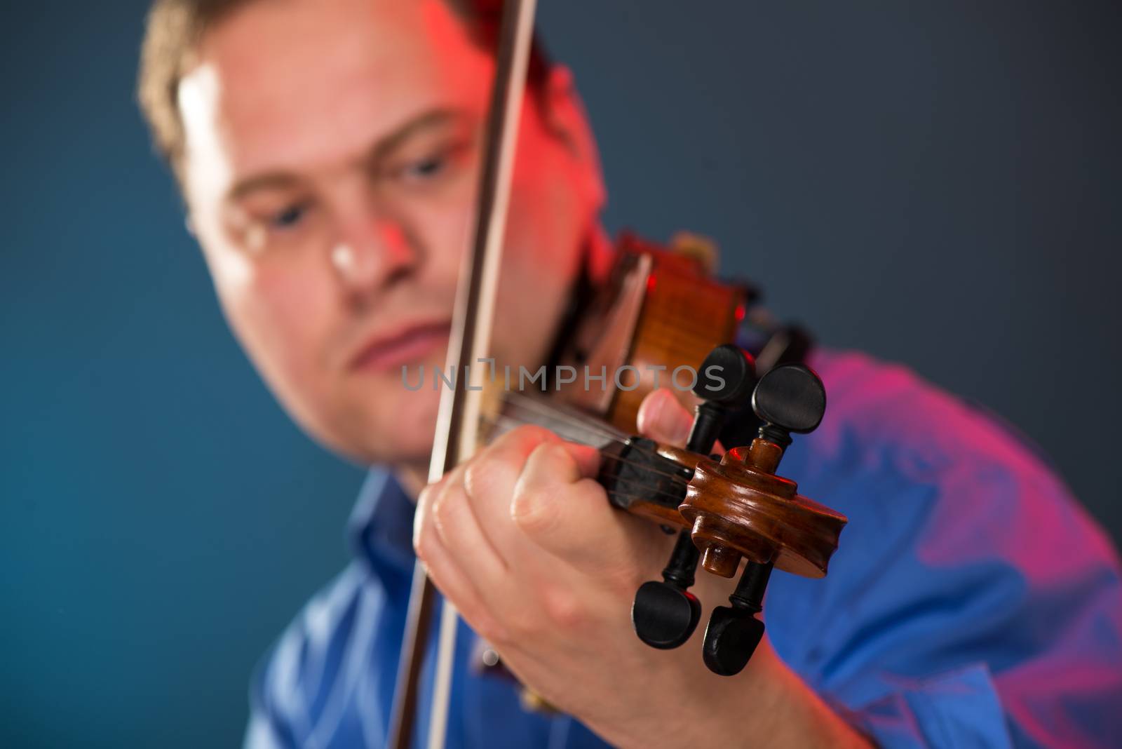 Close-up of violin in the hands of the violin virtuoso with a face out of focus.