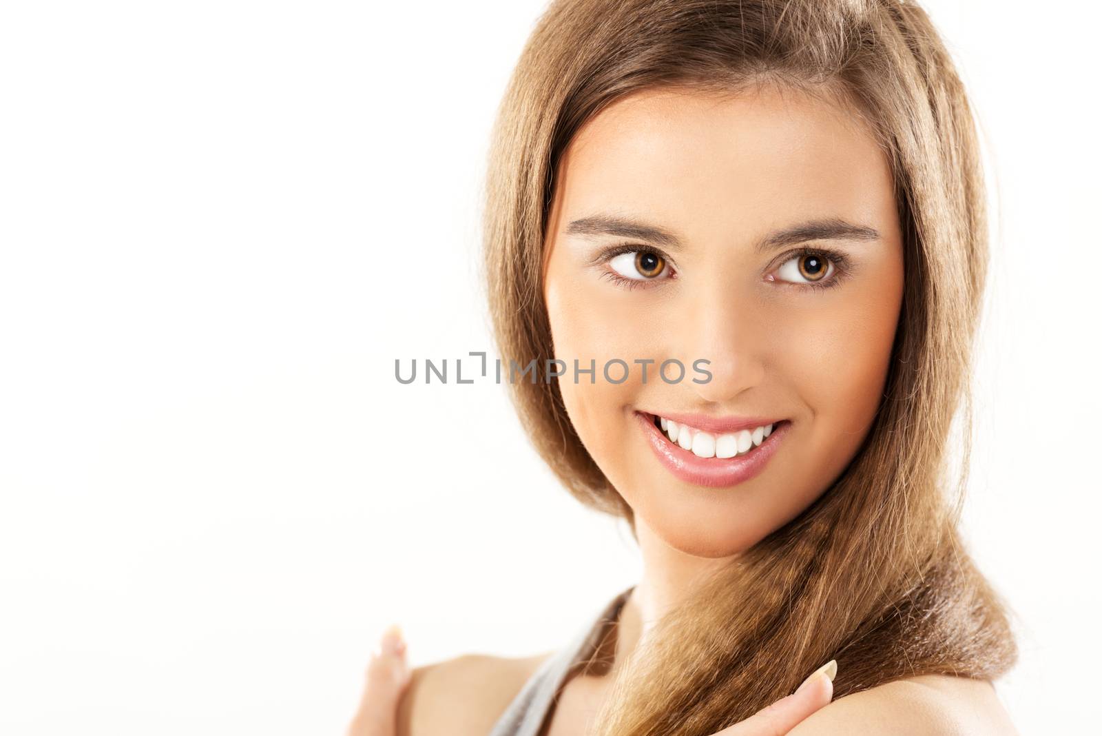 Close-up of beautiful smiling girl with brown hair and brown eyes.
