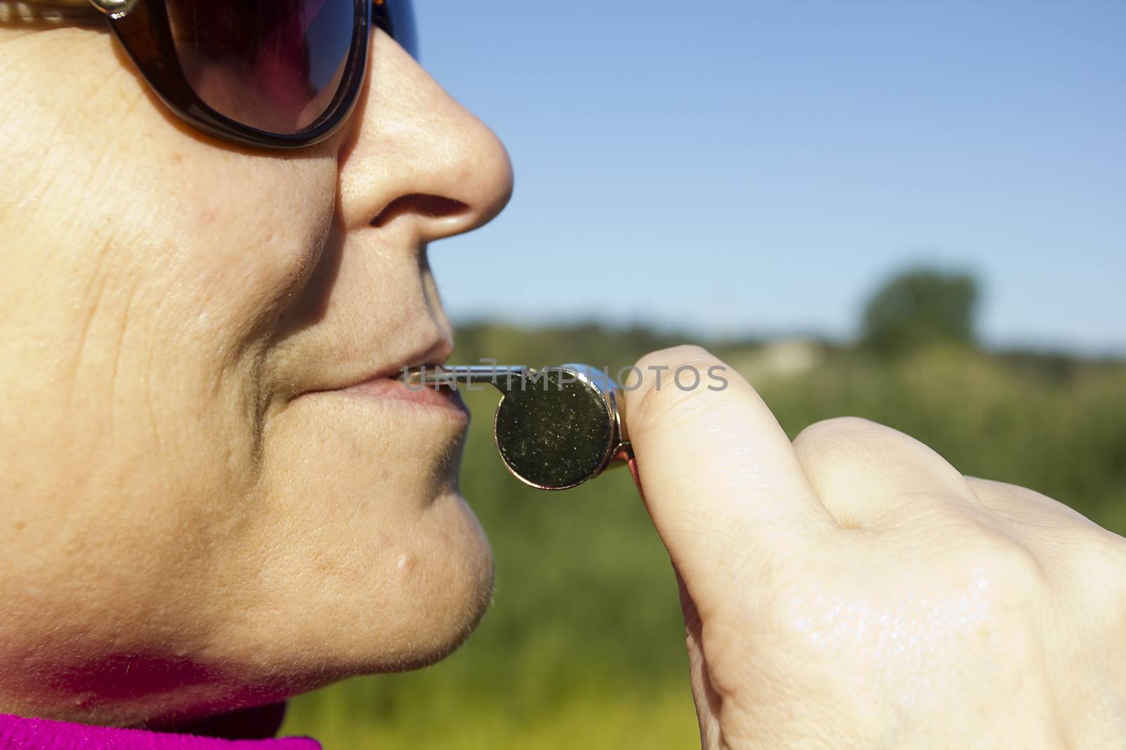 Portrait of a woman with a whistle coach outdoors