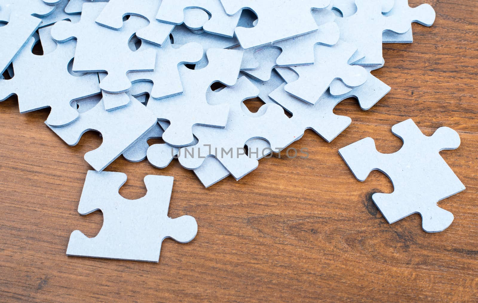 Pile of puzzle pieces on table, top view. Close-up