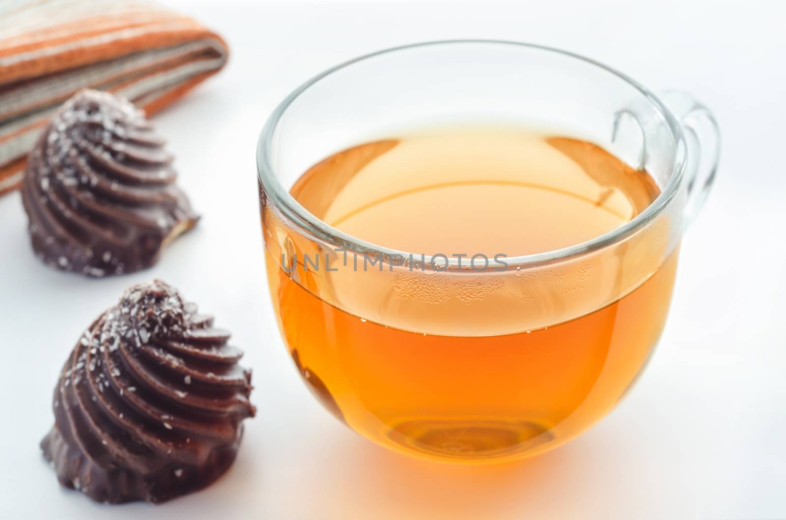 Tea in glass Cup and chocolate candies on table, natural light in the morning.