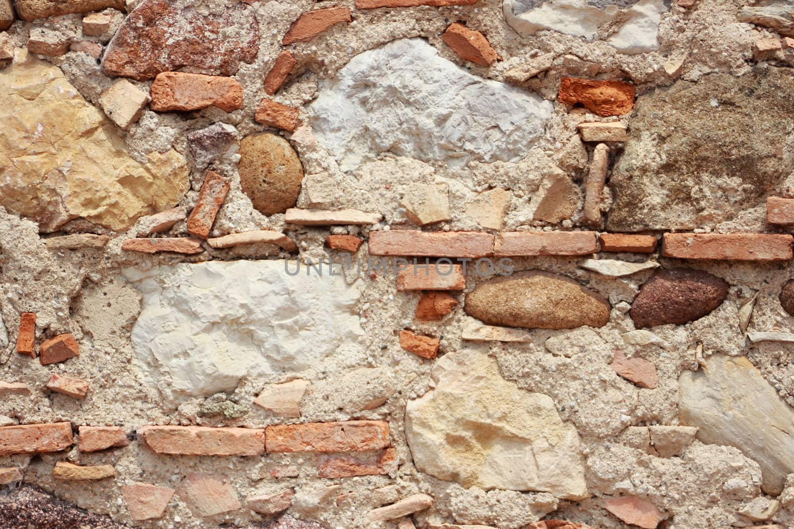 Unstructered wall with rocks tiles and cement