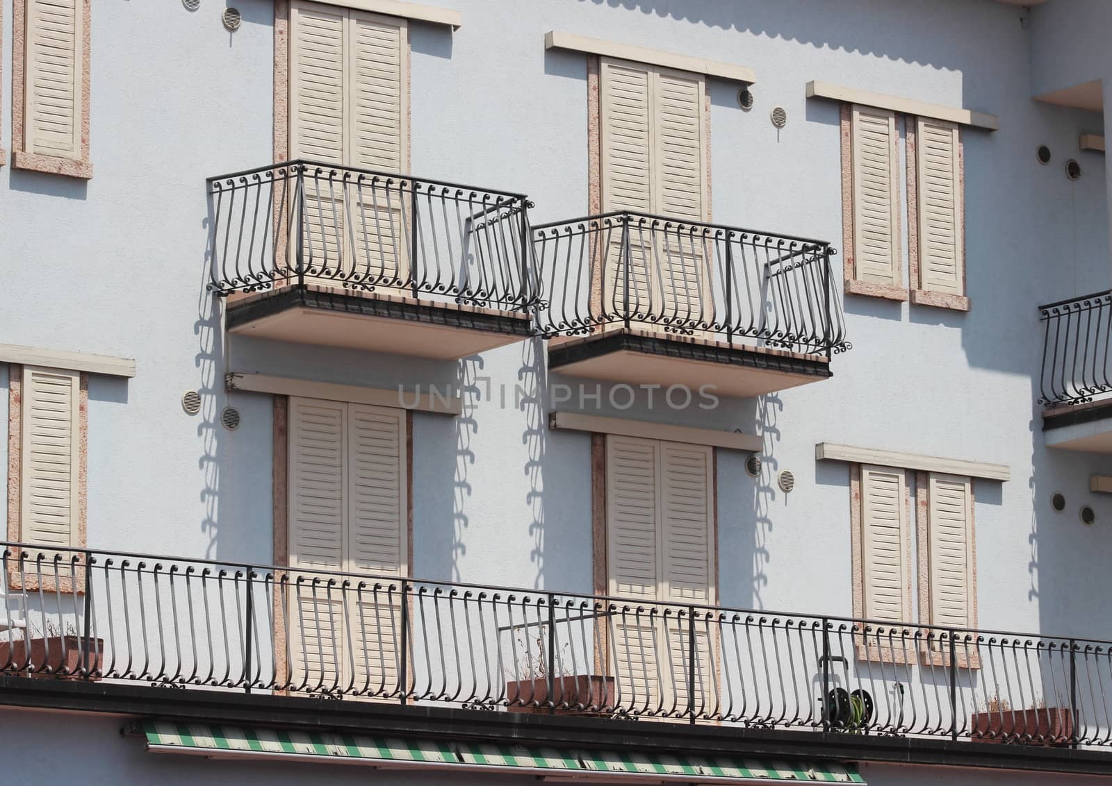 Facade af building with balcony and iron fence