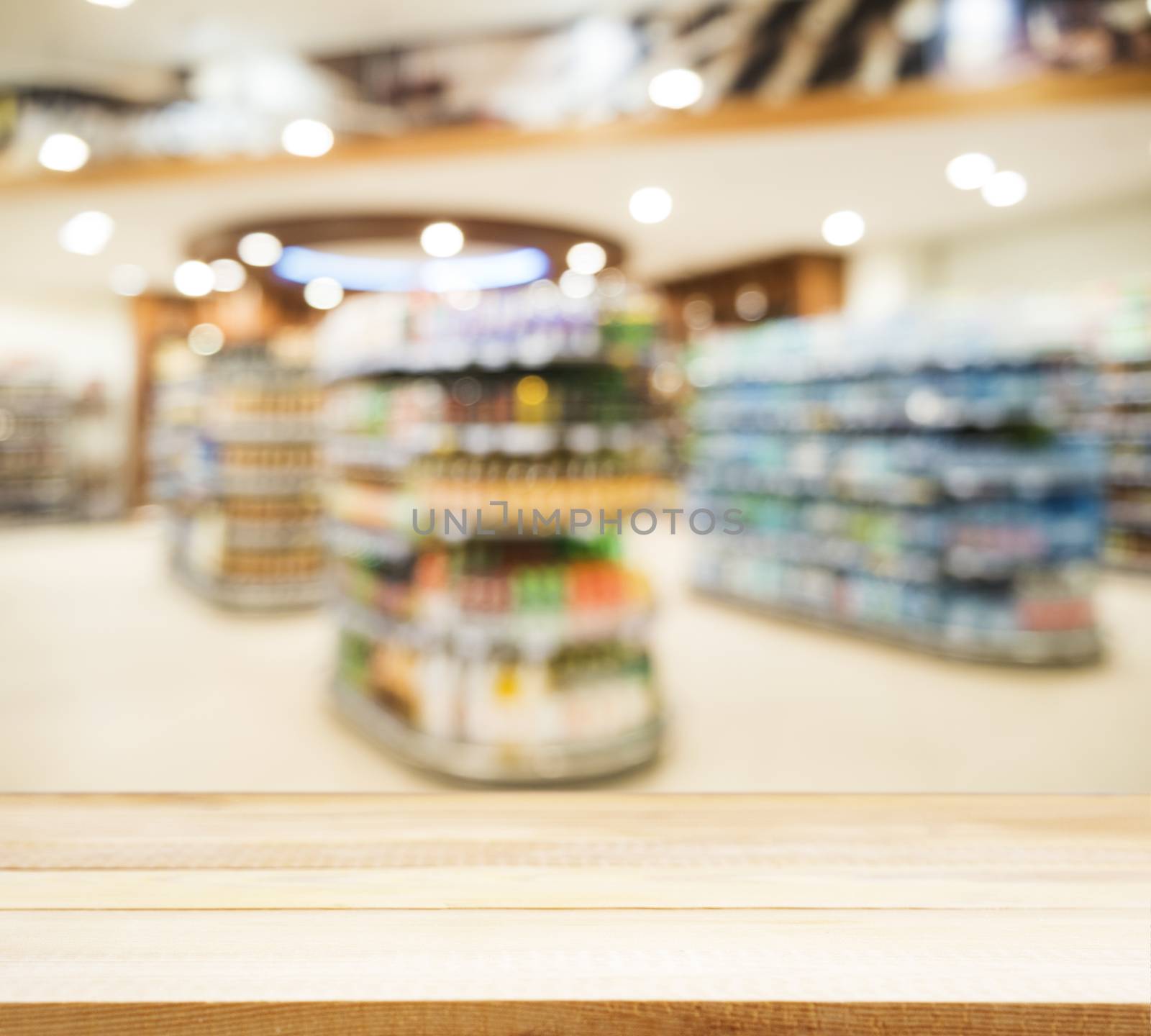 Wooden empty table in front of blurred supermarket by fascinadora