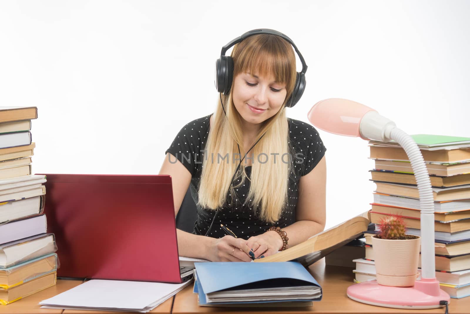 Student listening to music on headphones engaged in preparing for the exam by Madhourse