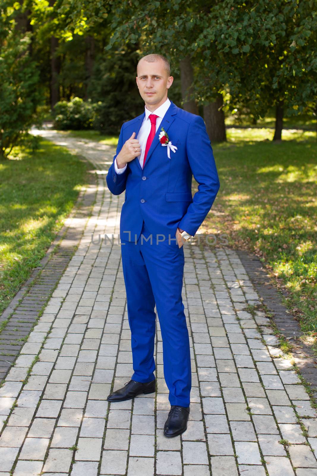 groom in a blue suit standing in the alley by lanser314