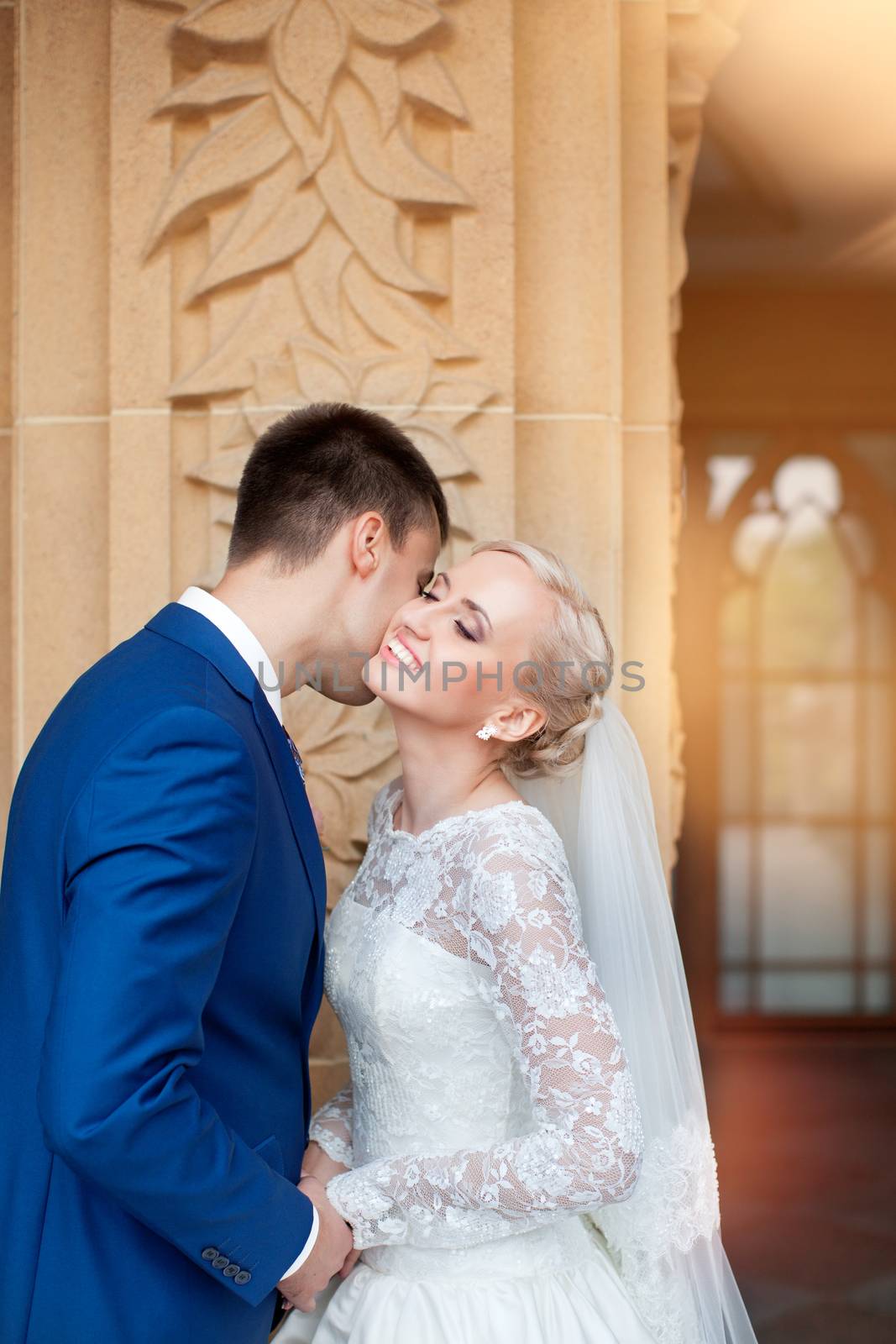 wedding couple hugging and kissing in a private moment of joy