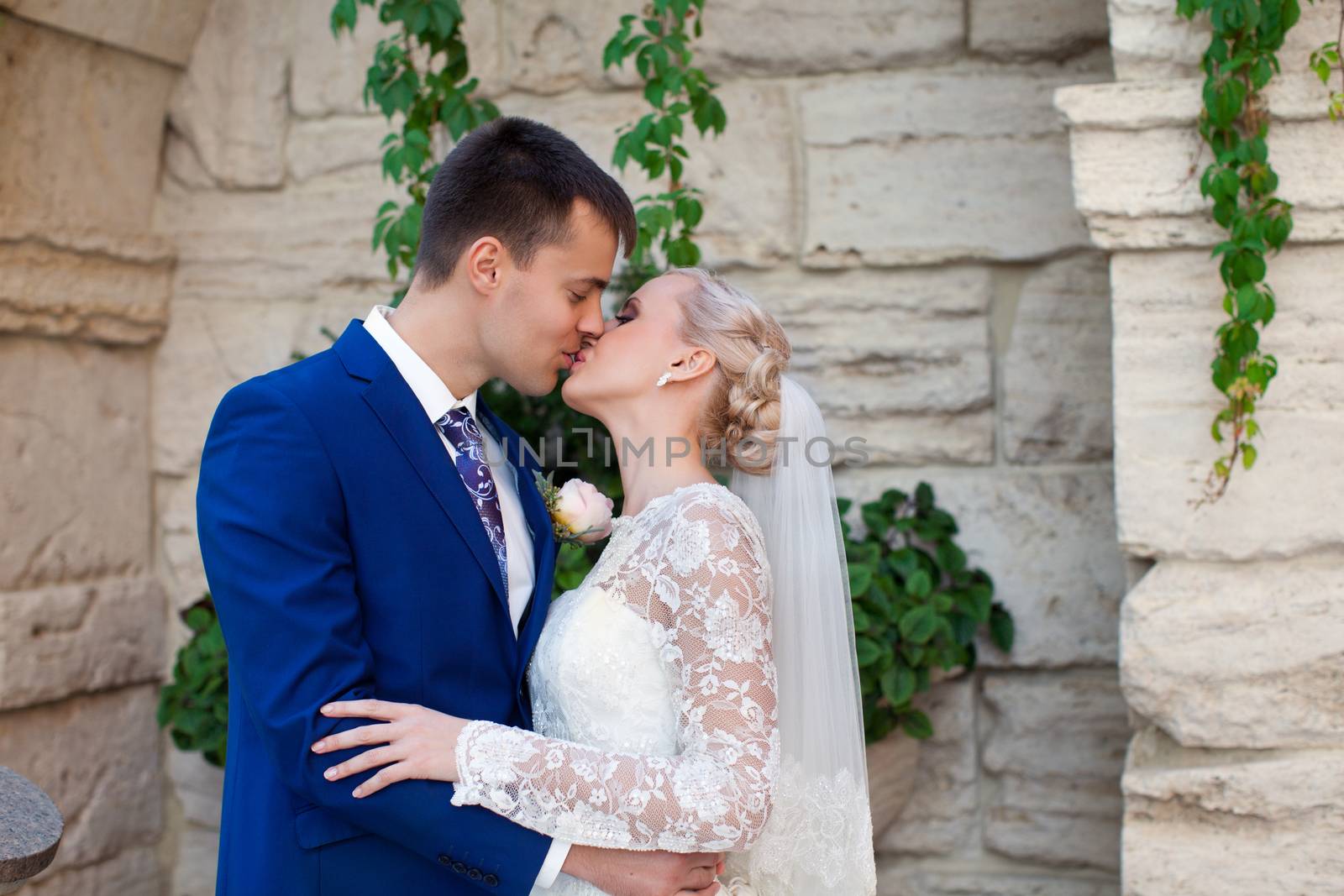 wedding couple hugging and kissing in a private moment of joy