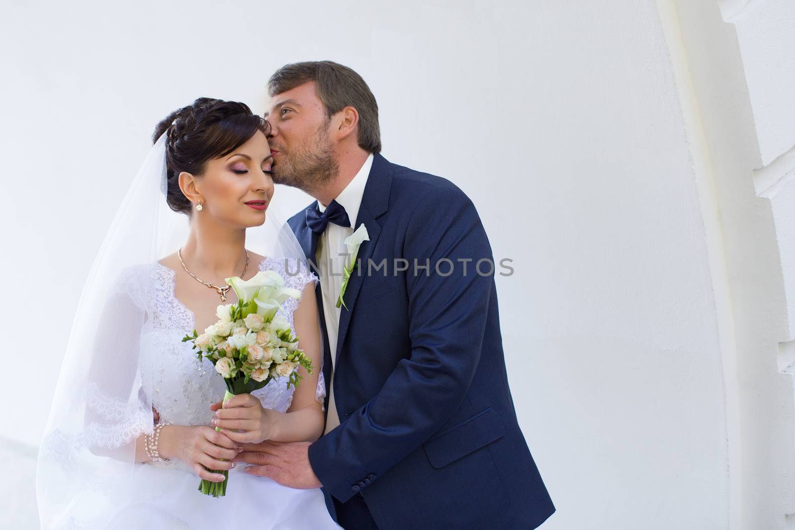 Wedding newlyweds kiss on a sunny day