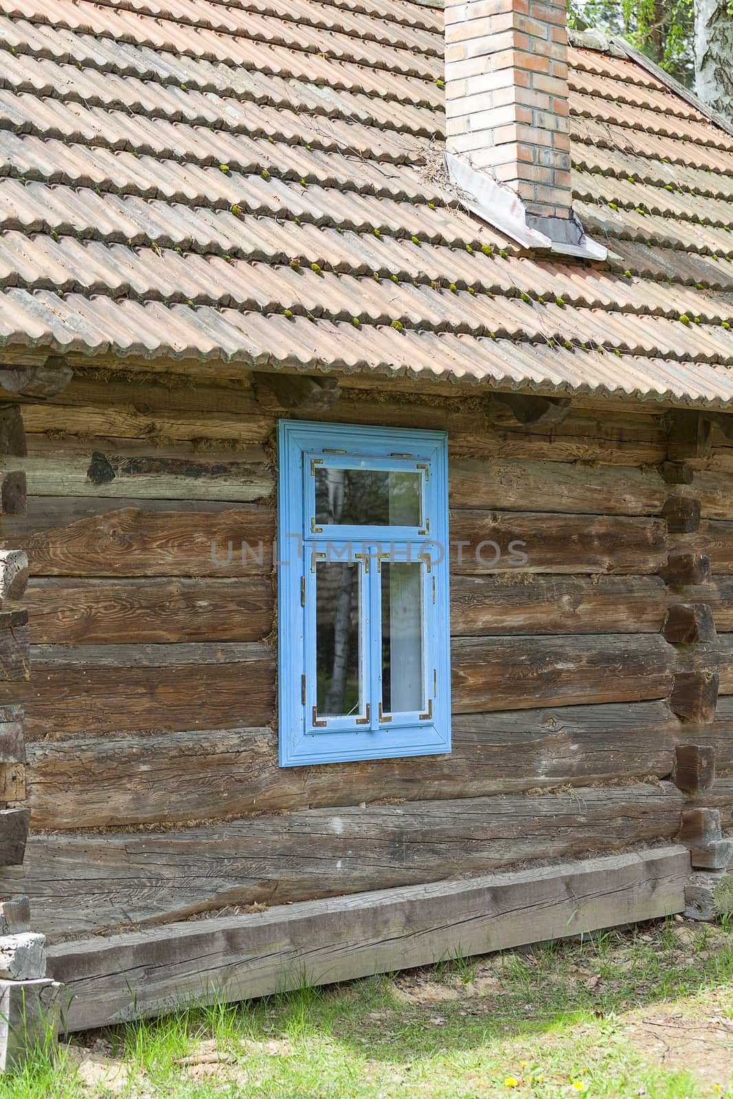 old traditional wooden polish cottage with blue window in open-air museum, Ethnographic Park, Kolbuszowa, Poland