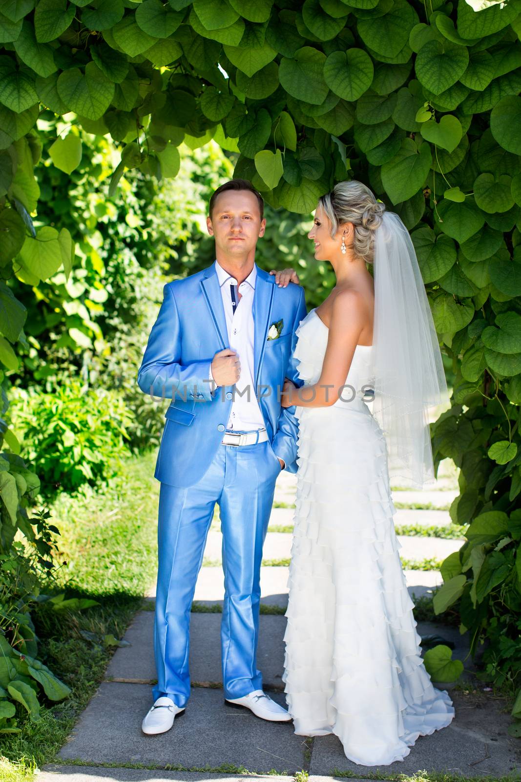 The groom gently kisses the bride on a summer day by lanser314