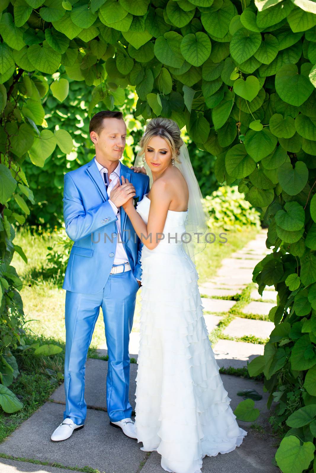 The groom gently kisses the bride on a summer day