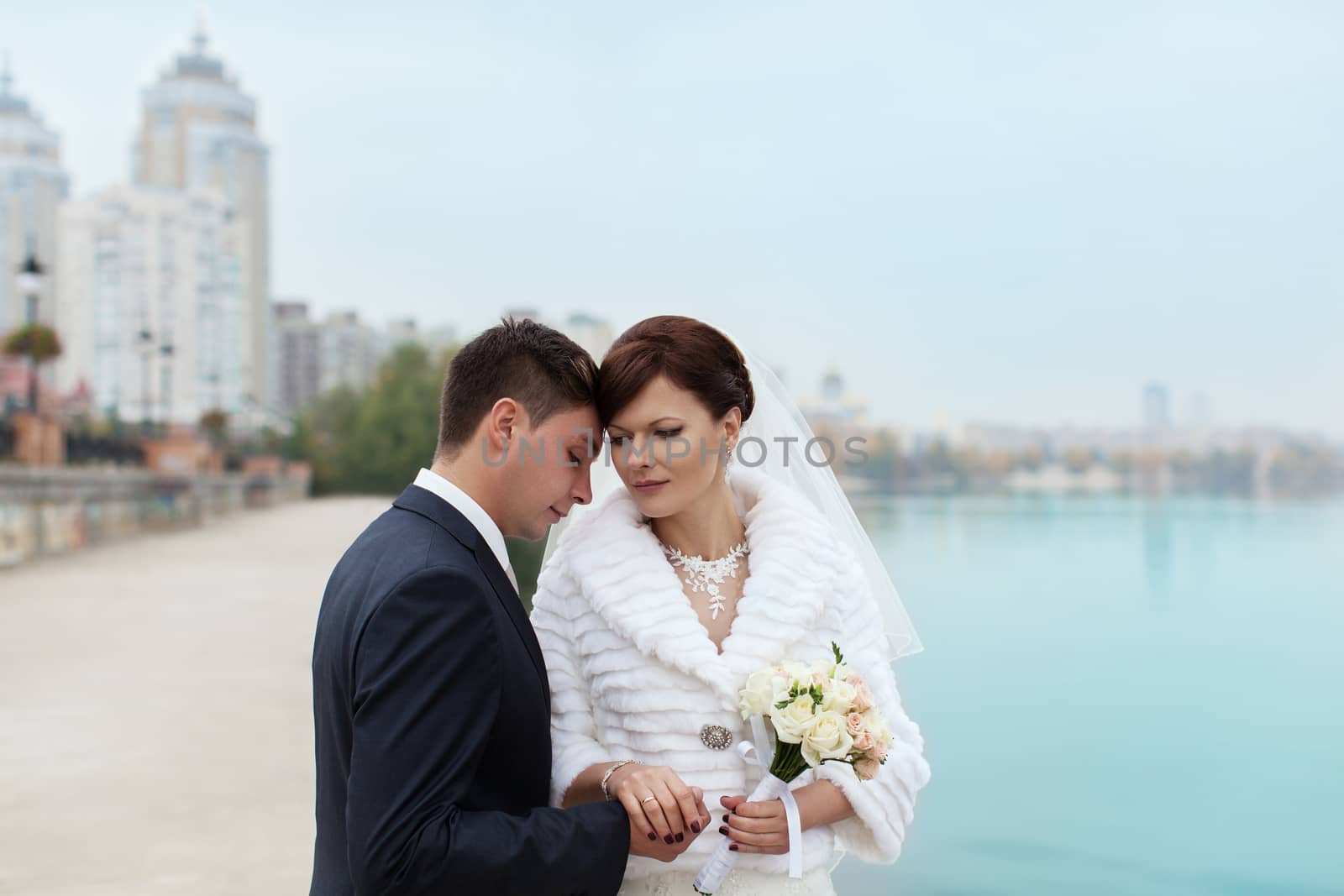 groom gently touched to the bride on a pier near the sea