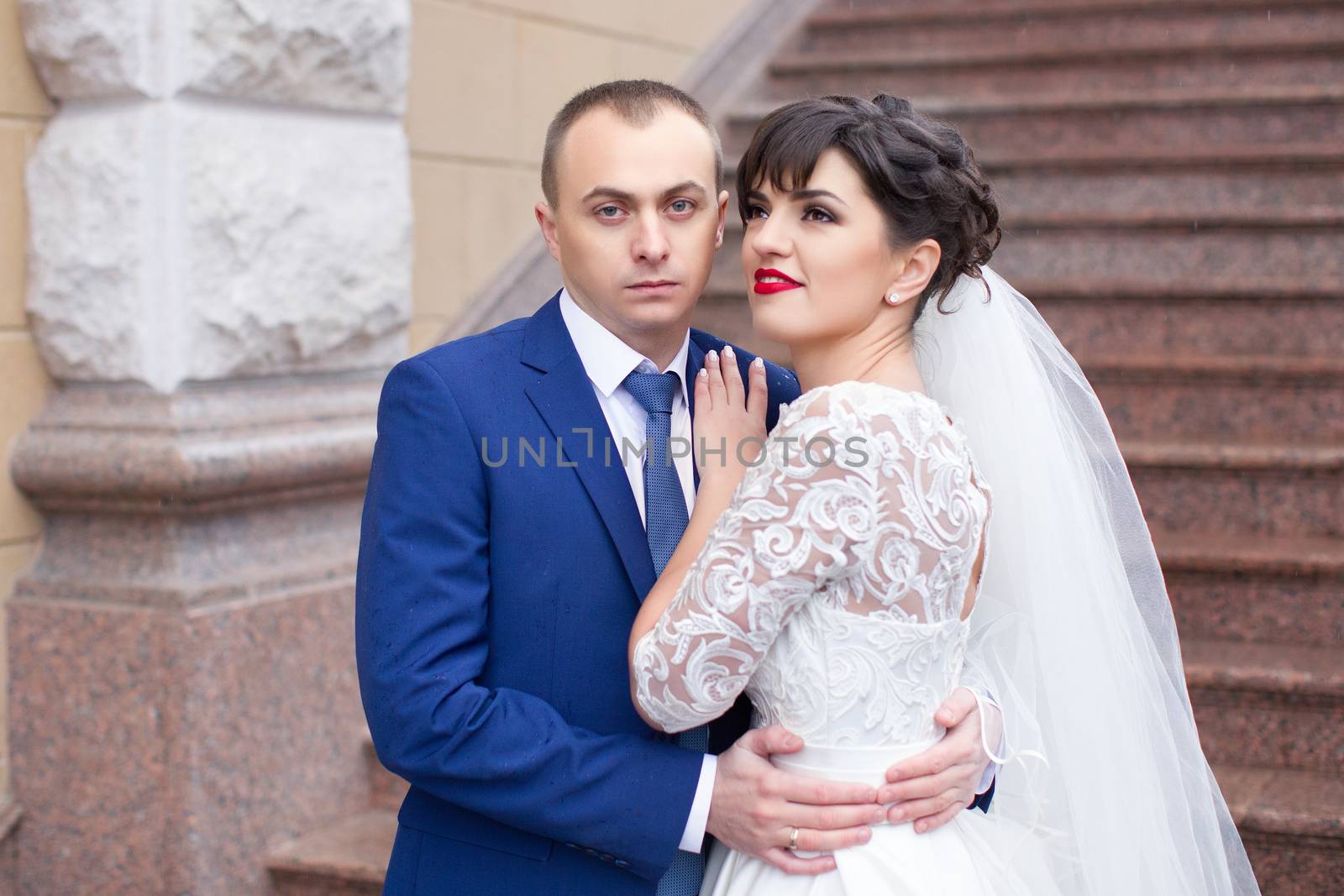 Bride and groom posing in the rain