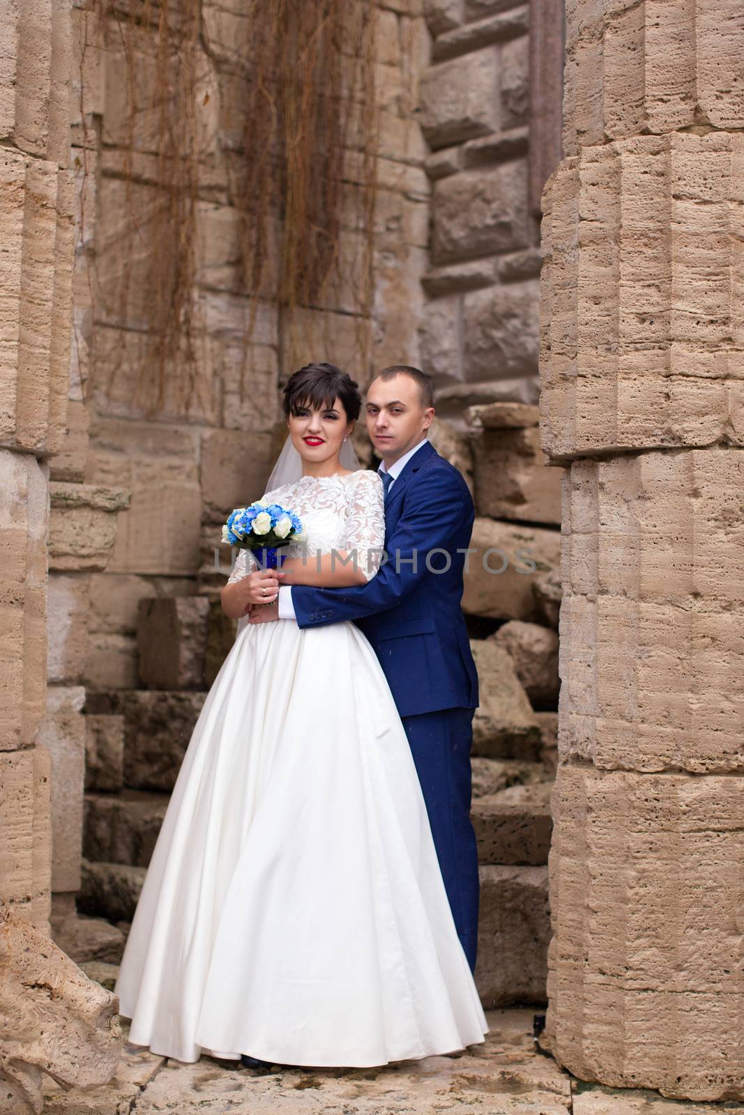 Couple standing in the rain on the wedding day by lanser314