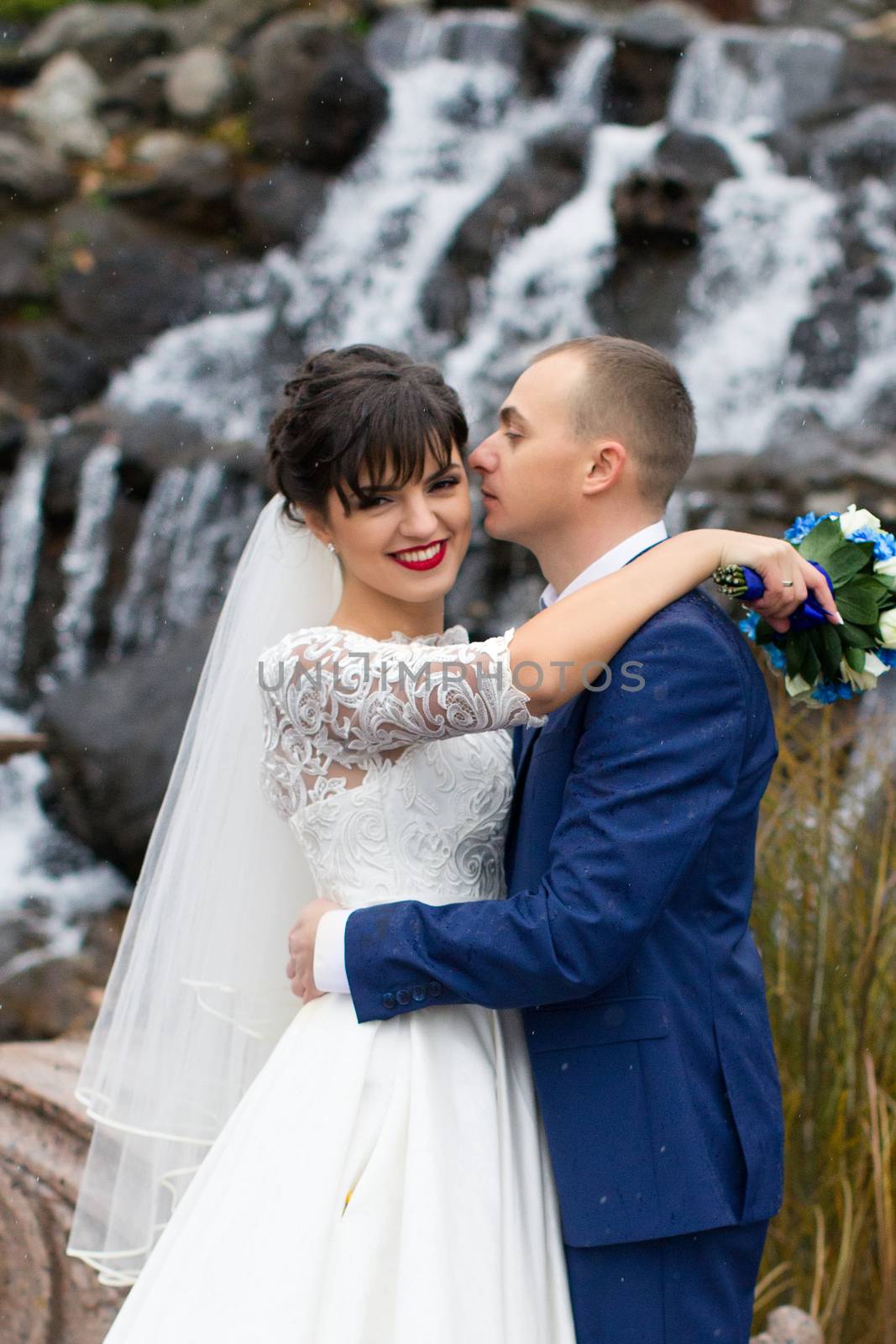 Bride and groom posing in the rain