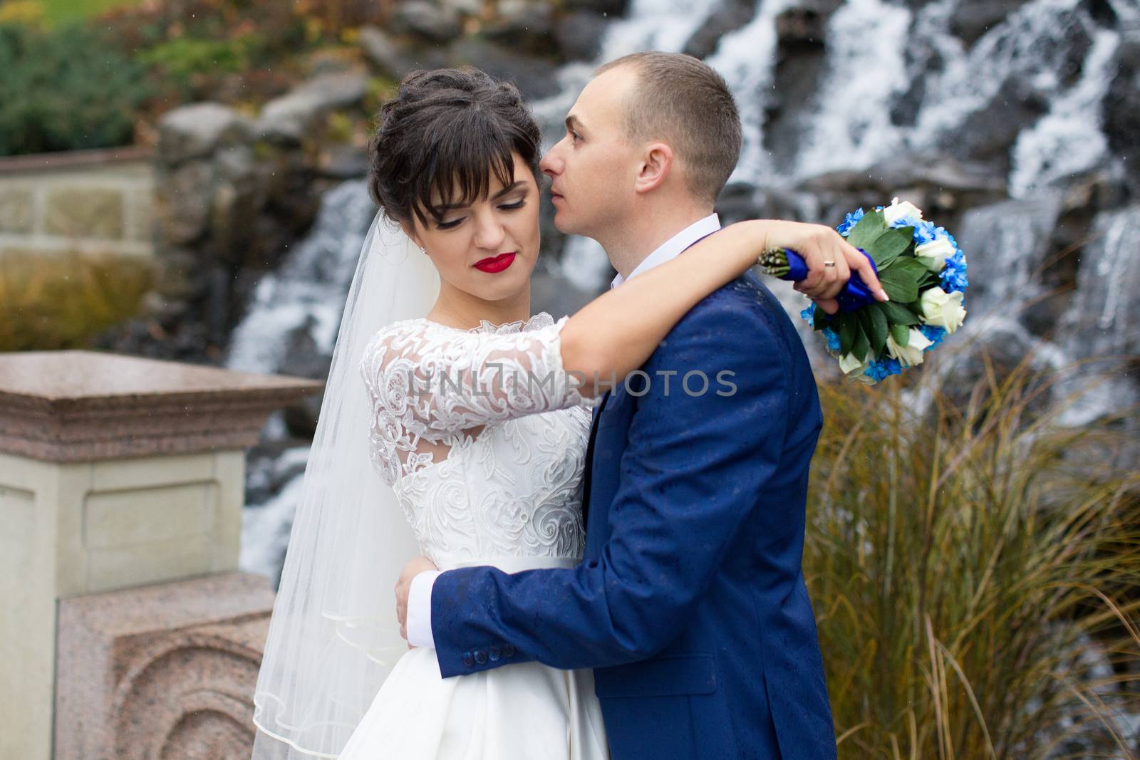 Couple standing in the rain on the wedding day by lanser314